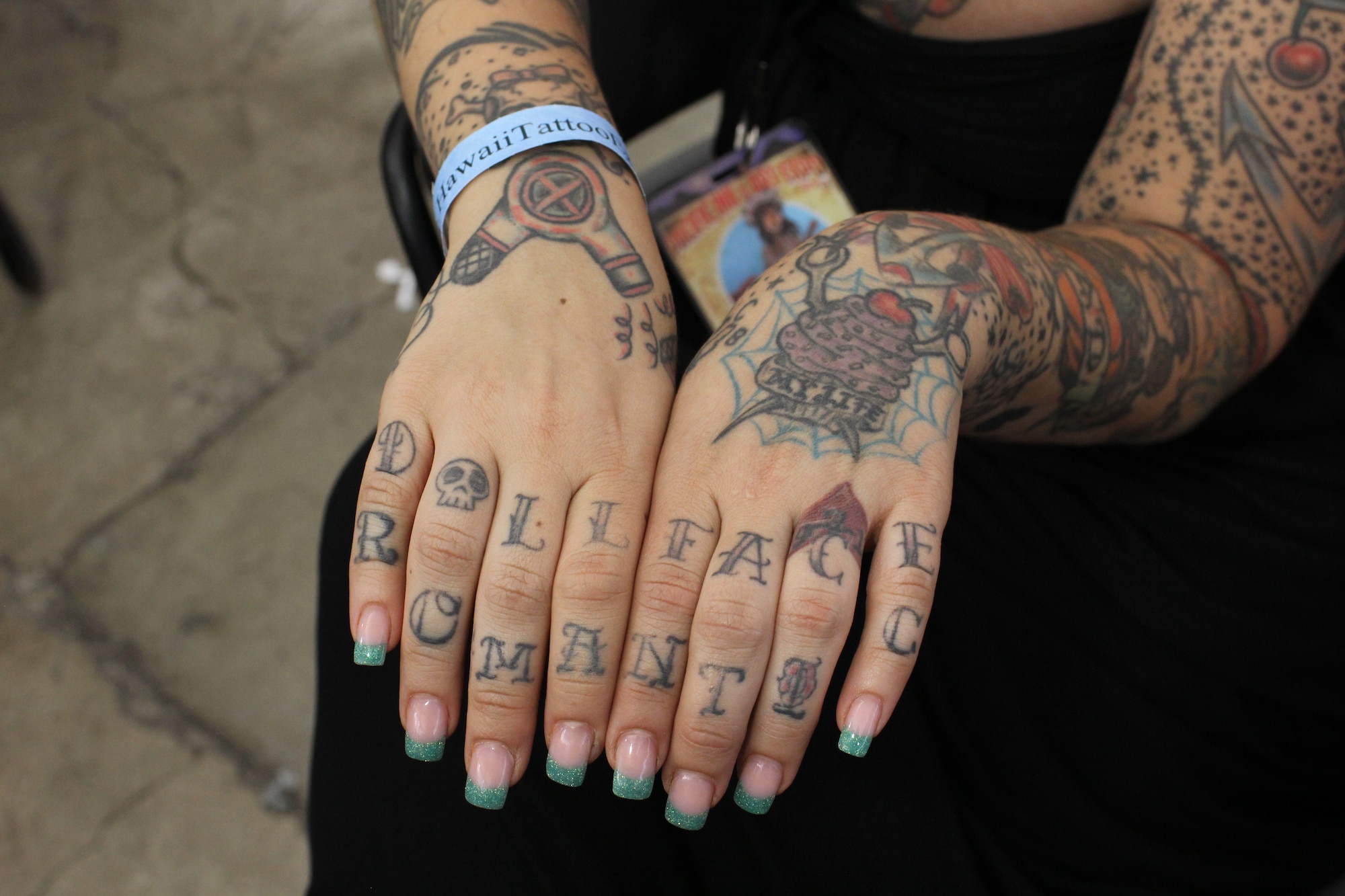 An attendee at the Pacific Ink & Art Expo displays the tattoo art on her hands, Blaisdell Exhibition Hall, Honolulu, Hawaii, Aug. 4, 2013. Her advice to those who have no tattoos was, "Don't do it!" She said that once one starts getting artwork done, it becomes addictive. According to the Air Force Instruction 36-2903,  According to the Air Force Instruction 36-2903, a tattoo exclusively on the hand is allowed, but cannot exceed 25% of the exposed hand since the hand is considered a separate body part when wearing a long-sleeve uniform item. (U.S. Air Force photo by Tech. Sgt. Phyllis Keith)