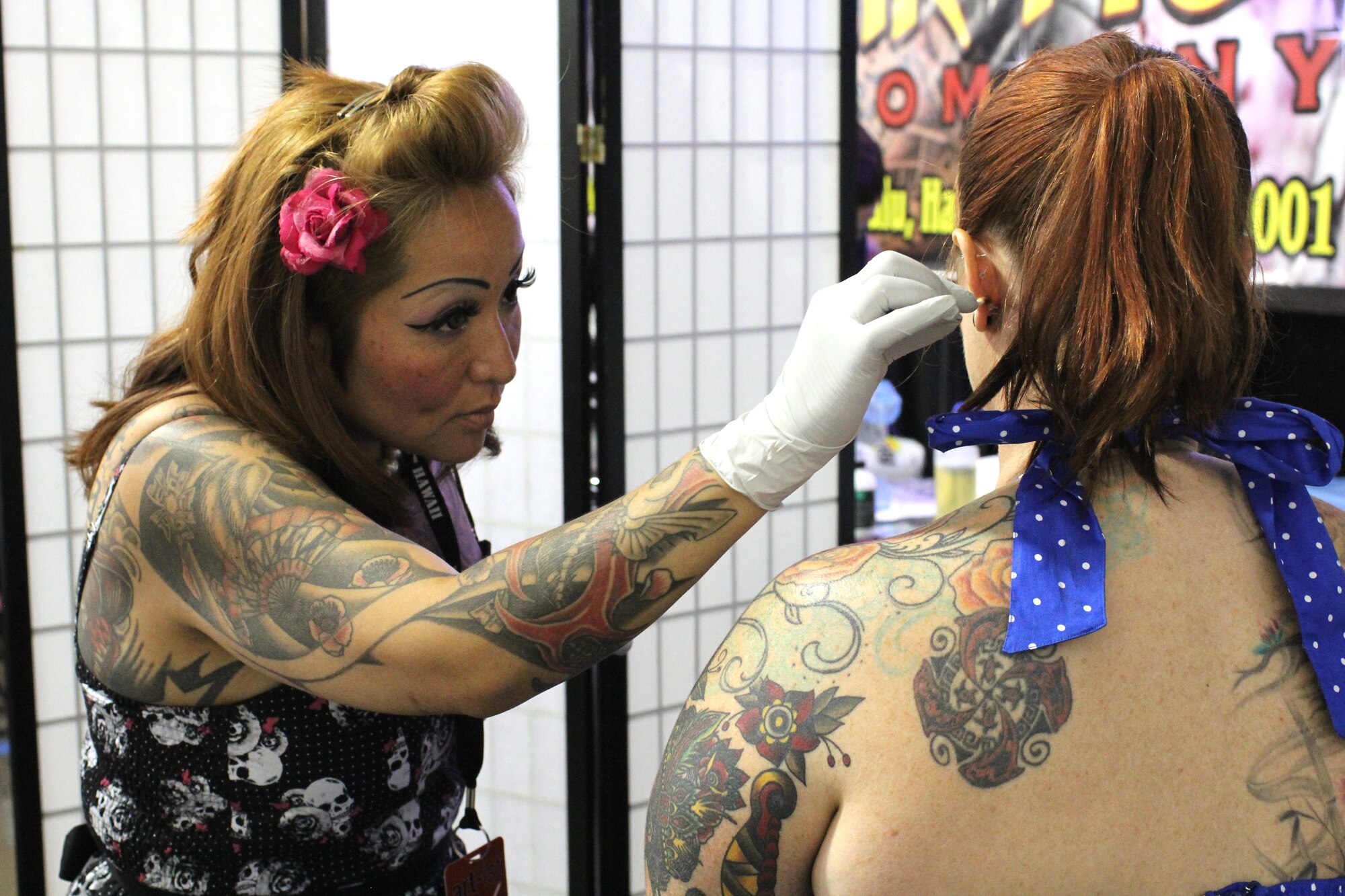 A woman, right, gets her ears pierced by a piercing specialist, left, at the Pacific Ink & Art Expo, Blaisdell Exhibition Hall, Honolulu, Hawaii, Aug. 4, 2013. According the Air Force Instruction 36-2903, all active duty Air Force personnel are "prohibited from attaching, affixing,or displaying objects, articles, jewelry or ornamentation to or through the ear, nose, tongue, eye brows, lips, or any exposed body part (includes visible through the uniform) on or off duty. This does not apply to Air Force Reservists in civilian status. (U.S. Air Force photo by Tech. Sgt. Phyllis Keith)
