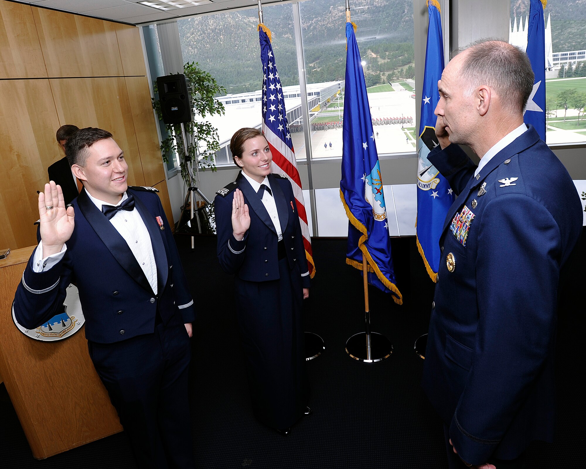 Col. Dale Holland, Academy vice commandant, issues the Oath of Office to new 2nd Lts. Orlando Saldana and Linnaea Hance during the summer graduation ceremony. These two lieutenants bring the Class of 2014’s graduation total to 997 graduates. (U.S. Air Force photo/Mike Kaplan)
