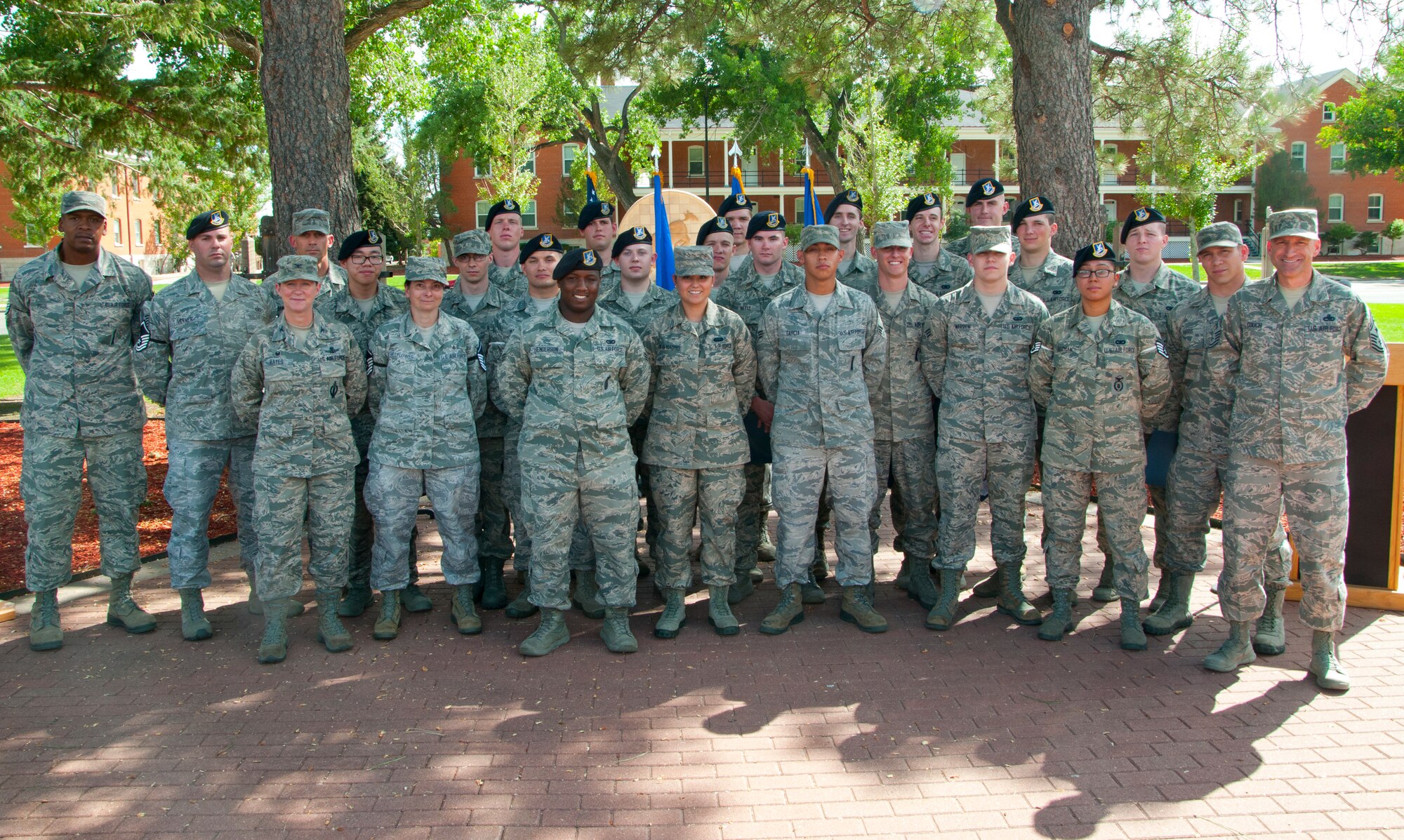 F.E. Warren July enlisted promotes pose with Col. Tracey Hayes, 90th Missile Wing commander, and Chief Master Sgt. Samuel Couch, 90th MW command chief, for a photo at the end of the July Wing Enlisted Promotion Ceremony July 31, 2014, in Prado Park. F.E. Warren celebrates its enlisted promotions each month. (U.S. Air Force photo by Airman 1st Class Jason Wiese)