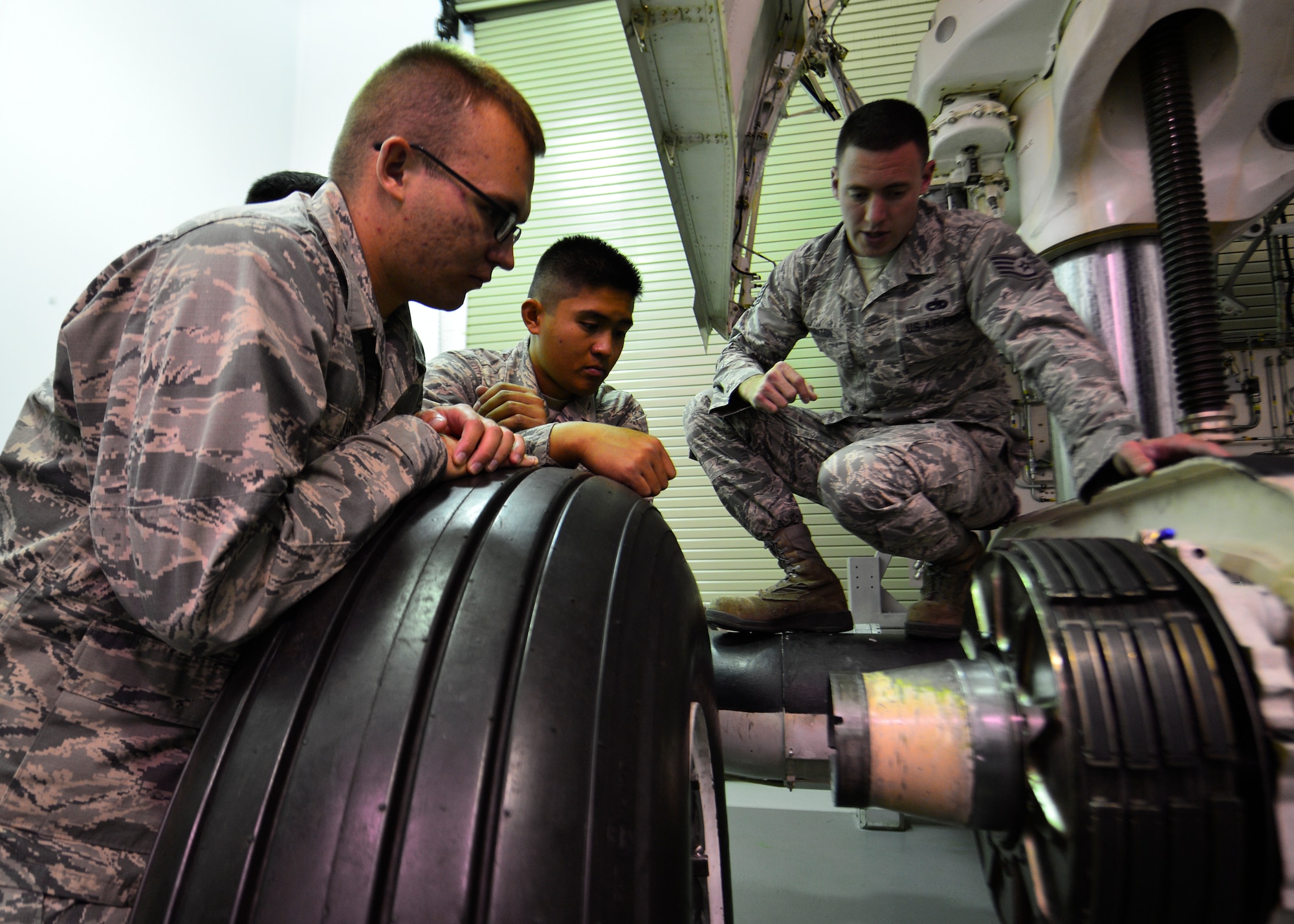 Staff Sgt. Chace Layton, 373d Training Squadron C-5 mission ready Airmen instructor, explains the axle inspection process after students removed a tire from the C-5M Super Galaxy main landing gear trainer July 28, 2014, at Dover Air Force Base, Del. Students learn how to change C-5 tires as and inspect axles as part of their training curriculum. (U.S. Air Force photo/Airman 1st Class William Johnson)