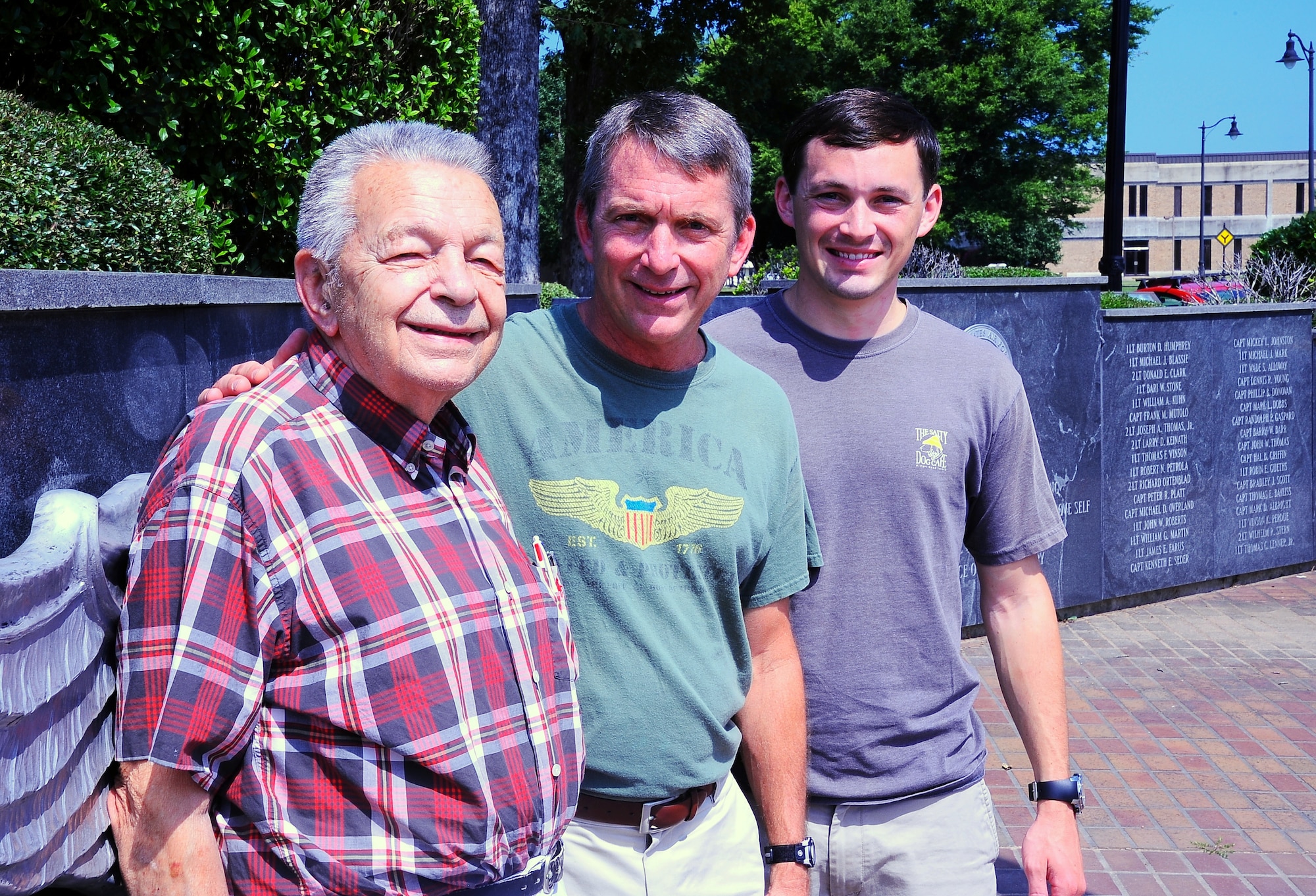 C. Veazey LeCraw stands with his son retired Lt. Col. Chris LeCraw and his grandson 2nd Lt. Matthew LeCraw at Columbus Air Force Base Smith Plaza July 26. When Matthew graduated Specialized Undergraduate Pilot Training, he became the fourth generation of officers and pilots.(U.S. Air Force photo/ Senior Airman Kaleb Snay)
