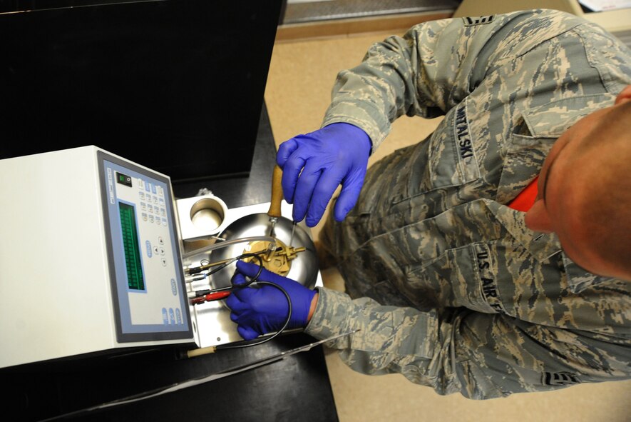 U.S. Air Force Staff Sgt. Andrew Mitalski, 20th Logistics Readiness Squadron fuels laboratory supervisor, puts fuel into a flash point tester at Shaw Air Force Base, S.C., August 1, 2014. The flash point tester heats the fuel to determine when it will ignite. The temperture should be upwards of 100 degrees. (U.S. Air Force photo by Airman 1st Class Michael Cossaboom/Released)