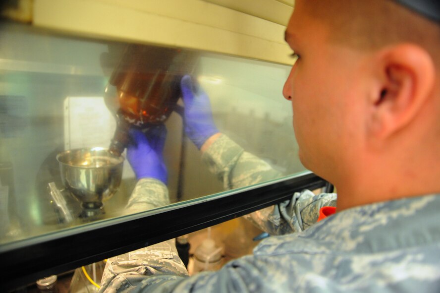 U.S. Air Force Staff Sgt. Andrew Mitalski, 20th Logistics Readiness Squadron fuels laboratory supervisor, pours jet fuel into a funnel at Shaw Air Force Base, S.C., August 1, 2014. When the Airmen inspect the fuel, they are checking to see if it meets Air Force requirments to be put into an aircraft. (U.S. Air Force photo by Airman 1st Class Michael Cossaboom)
