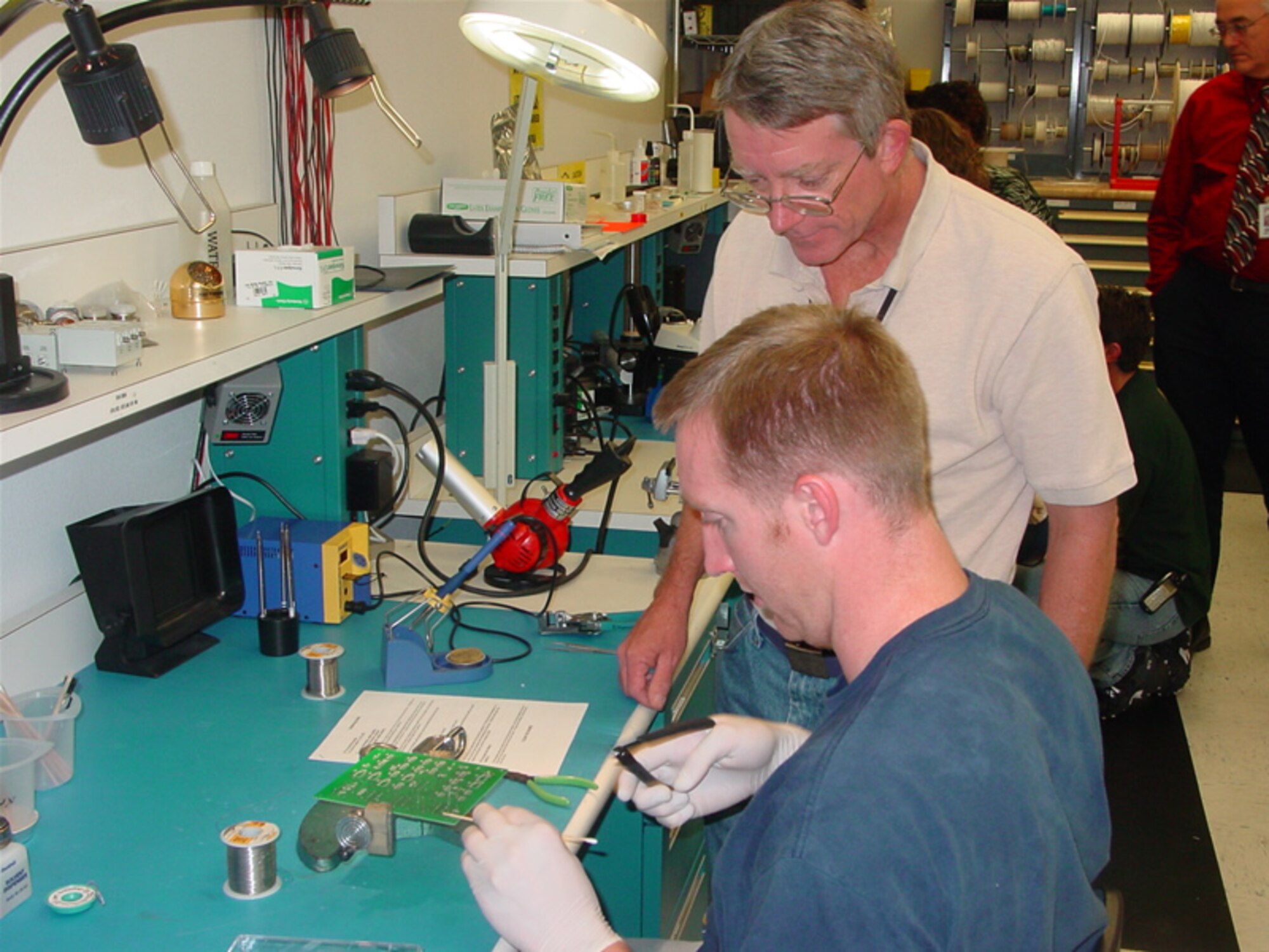 An Air Force Research Laboratory technician works with a student during the Nanosat-4 Satellite Fabrication class. (Courtesy photo)