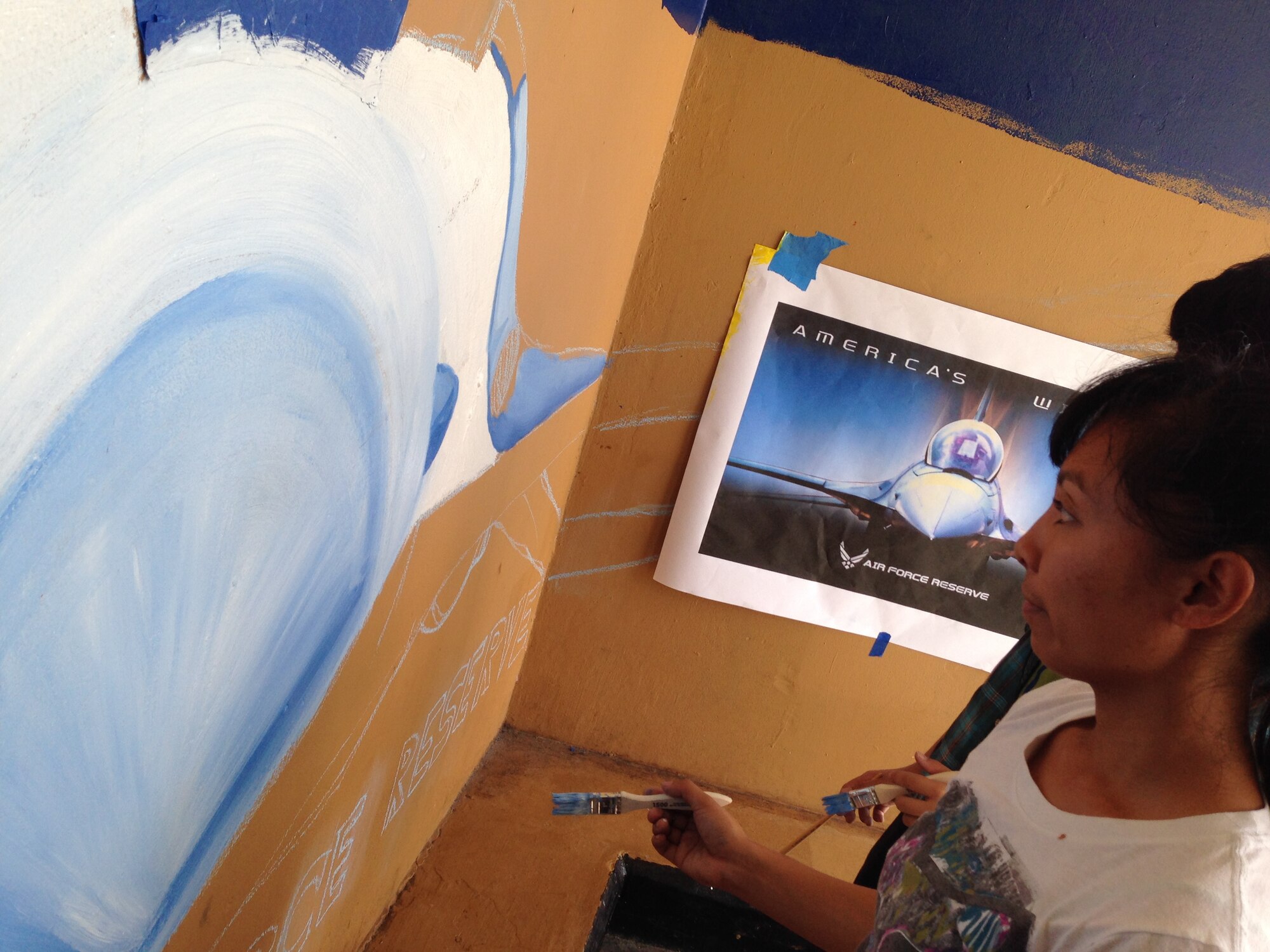 Air Force Reserve trainee Leodith Abinales pauses to inspect her artwork at a bus stop in the village of Mangilao, Guam. Abinales who is currently in basic training at Lackland Air Force Base, Texas, was assigned to a Development and Training Flight (D&TF) at the time, Nov. 20, 2013., with other new recruits waiting to go to basic training. The flight adopted the bus stop as part of the Lieutenant Governor of Guam’s Islandwide Beautification Task Force. When Abinales returns from basic training, she will be assigned to the 44th Aerial Port Squadron, 624th Regional Support Group, an Air Force Reserve unit located at Andersen Air Force Base, Guam. (Courtesy photo/Staff Sgt. Michael P. Shinohara)
