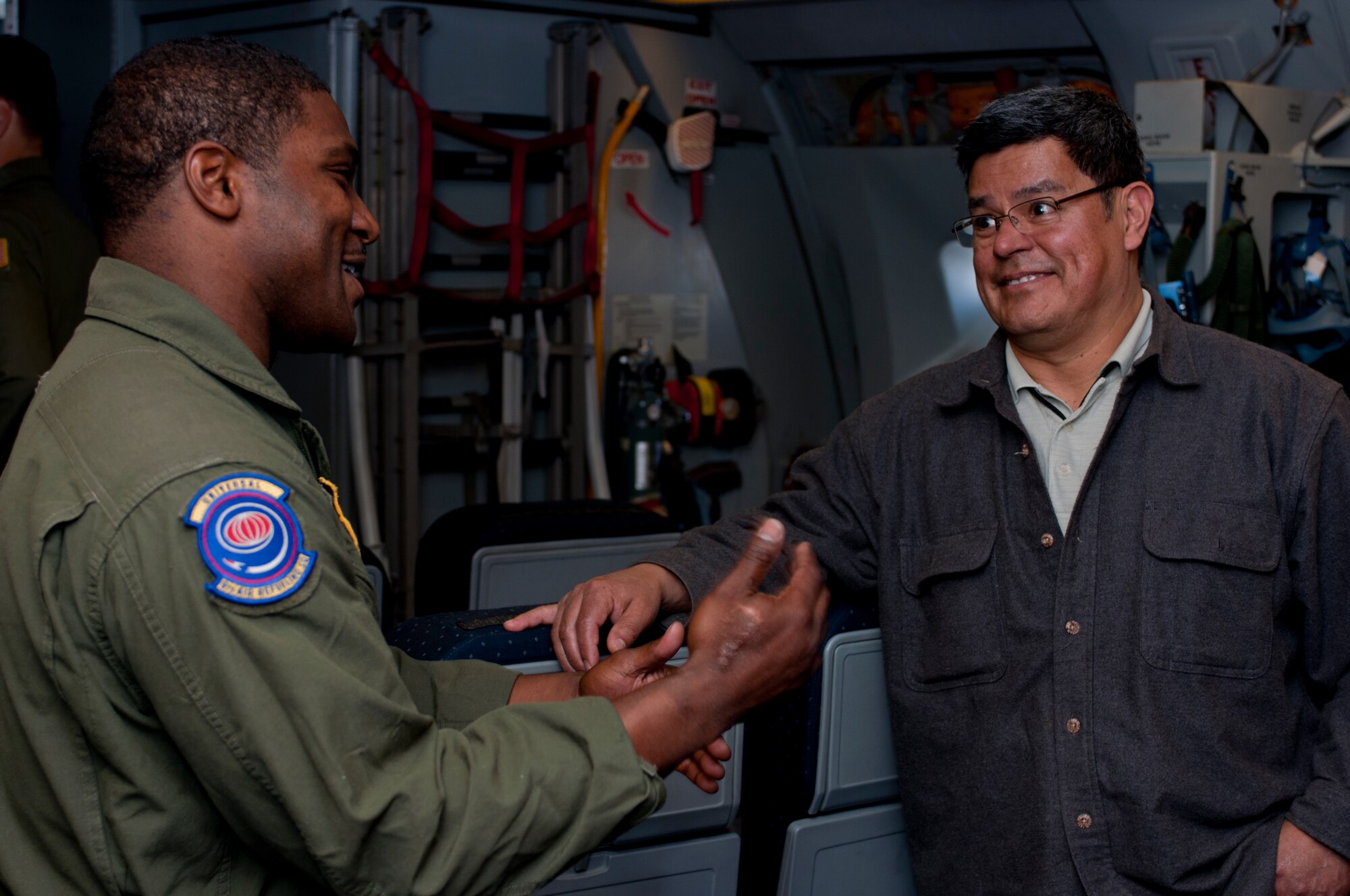 Staff Sgt. Kevin Simon, 9th Air Refueling Squadron boom operator, talks with Alfredo Moreno, 60th Maintenance Squadron aero repair shift supervisor, during a KC-10 Extender orientation flight July 23, 2014. (U.S. Air Force photo by Senior Airman Charles Rivezzo)
