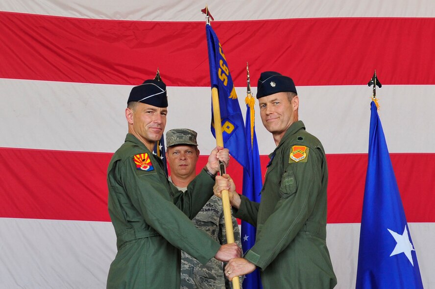 Brig. Gen. Scott Pleus, 56th Fighter Wing commander, passes the 56th Operations Group guidon to Lt. Col. William Bailey, incoming commander, July 25 at Luke Air Force Base. (U.S. Air Force photo/Senior Airman Grace Lee)