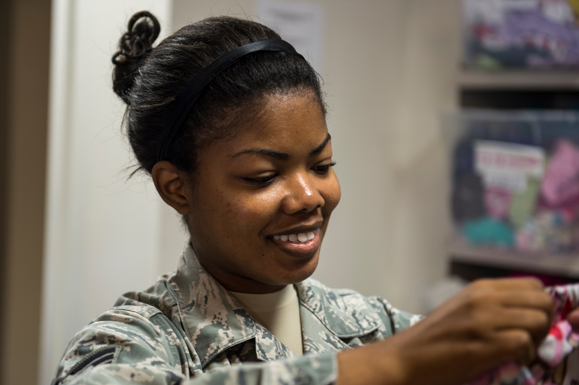 Senior Airman Chandreka Gore, 1st Special Operations Support Squadron air traffic controller, folds children’s clothes at the Airman’s Attic on Hurlburt Field, Fla., July 30, 2014. Gore volunteers at the Airman’s Attic 15 hours a week. (U.S. Air Force photo/Airman 1st Class Jeff Parkinson)