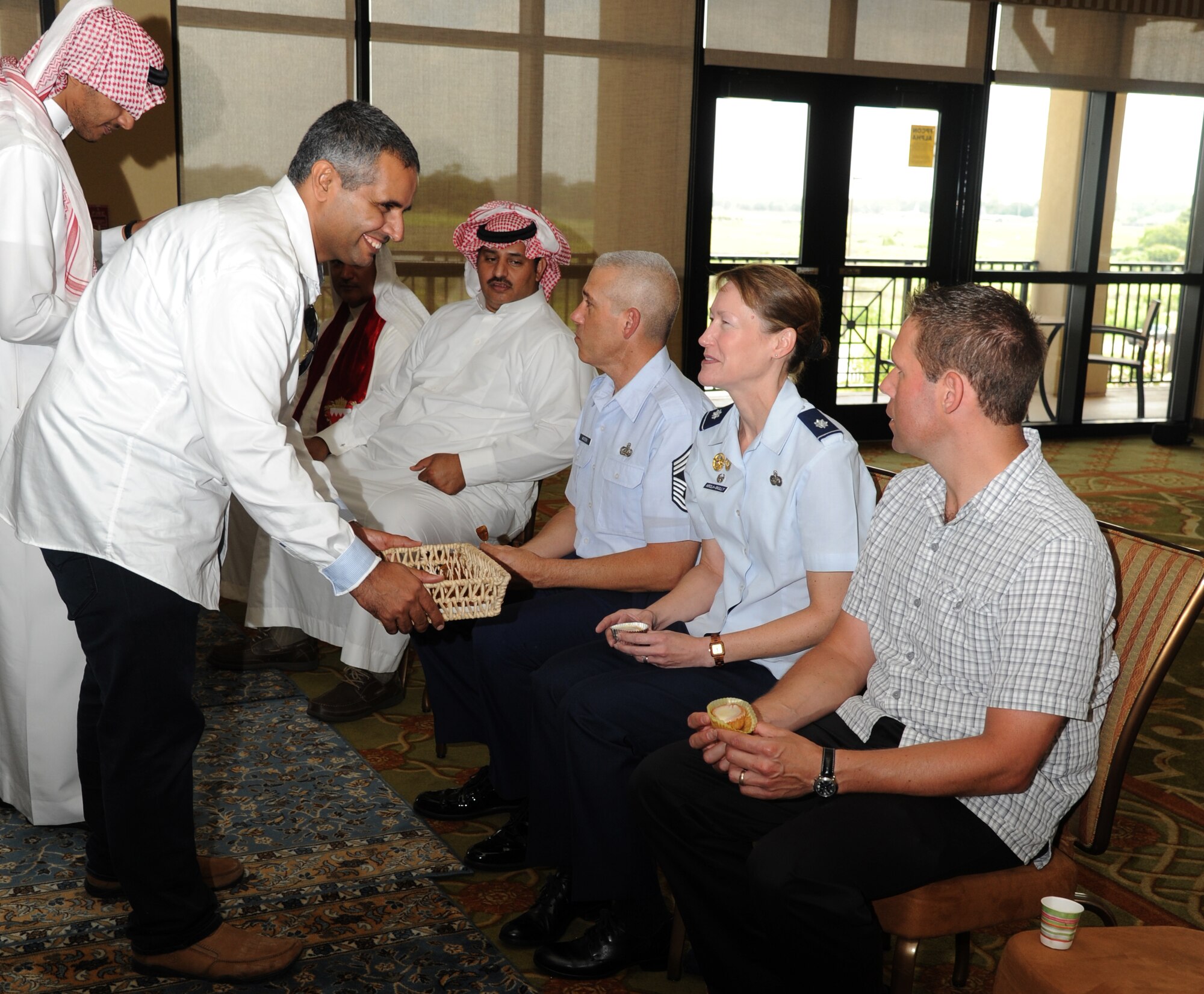 Chief Master Sgt. Abdullah Al Ghamdi, 334th Training Squadron international student, offers food samples to Lt. Col. Susan Airola-Skully, 81st Mission Support Group commander, and her husband during a luncheon to celebrate Eid al-Fitr, July 28, 2014, at the Bay Breeze Event Center, Keesler Air Force Base, Miss. Ramadan is a month dedicated to worship and repentance. Muslims worldwide observe this month by fasting from dawn until sunset. Eid al-Fitr is a three-day celebration that marks the end of Ramadan. (U.S. Air Force photo by Kemberly Groue)