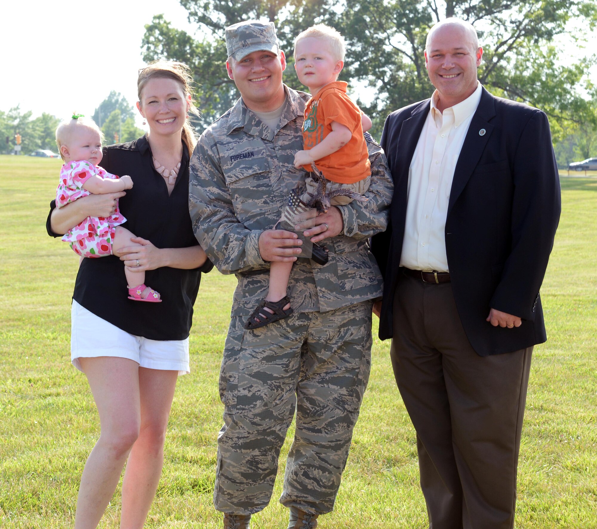 Staff Sgt. Cody Foreman and his family pose with Mark Lear, USO vice president of the board of directors, after Foreman was presented the USO Armed Forces Salute Award at Whiteman Air Force Base, Mo., July 25, 2014. The award recognizes military members for their leadership, military accomplishments and service to others. (U.S. Air Force photo by Airman 1st Class Emili Koonce/Released)