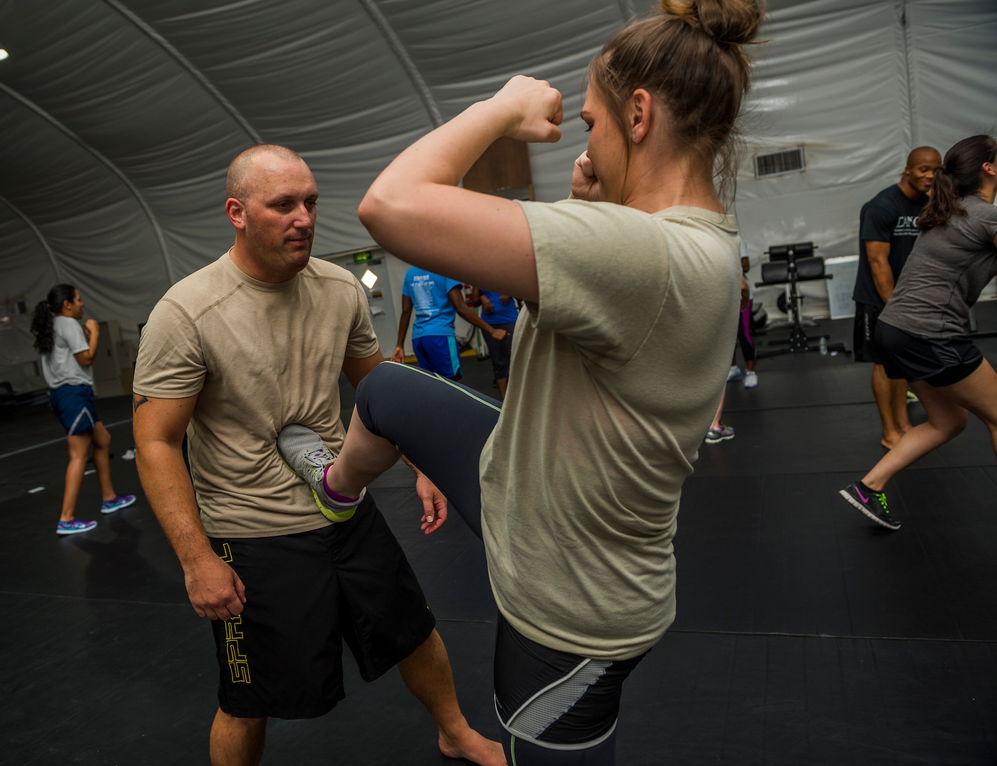 U.S. Air Force Master Sgt. Patrick Smith, 386th Air Expeditionary Wing Check Six superintendent, takes a kick to the stomach while teaching Staff Sgt. Rachelle Pritchett, 386th Expeditionary Force Support Squadron, one way to push away an attacker during a self-defense class July 26, 2014 at an undisclosed location in Southwest Asia. The class was designed to better prepare Airmen if they are ever attacked. (U.S. Air Force photo by Staff Sgt. Jeremy Bowcock)