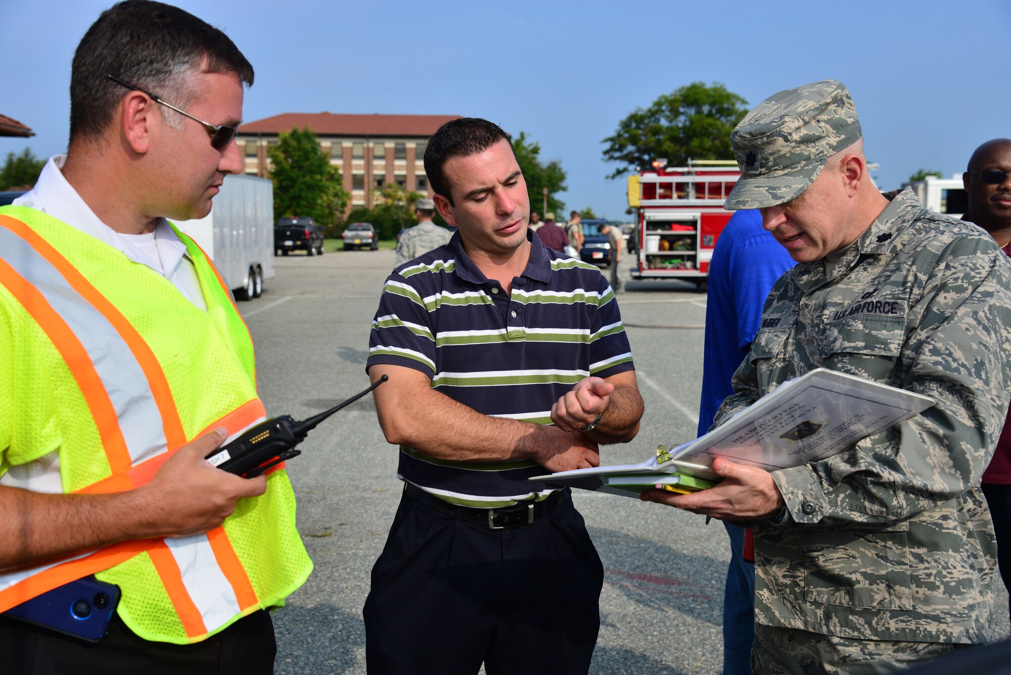 From left, John LaPorte, 633rd Civil Engineer Squadron assistant chief of operations, Mike Mallozzi, 633rd CES water quality manager, and U.S. Air Force Lt. Col. David Huber, 633rd CES deputy commander, discuss the details of a simulated fuel spill during an exercise at Langley Air Force Base, Va., July 31, 2014. Fuel spill exercises are conducted to observe emergency response teams as they assess the situation and contain the spill. (U.S. Air Force photo by Senior Airman Aubrey White/Released)