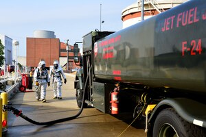 U.S. Air Force Staff Sgt. Alexis Smith, 633rd Civil Engineer Squadron fire protection crew chief, and Airman 1st Class Scott Kolar, 633rd CES fire protection journeyman, approach a fuel truck during a simulated fuel spill exercise at Langley Air Force Base, Va., July 31, 2014. During the exercise, approximately 1,000 gallons of fuel spilled, initiating response efforts to contain and clean-up the fuel. (U.S. Air Force photo by Senior Airman Aubrey White/Released)