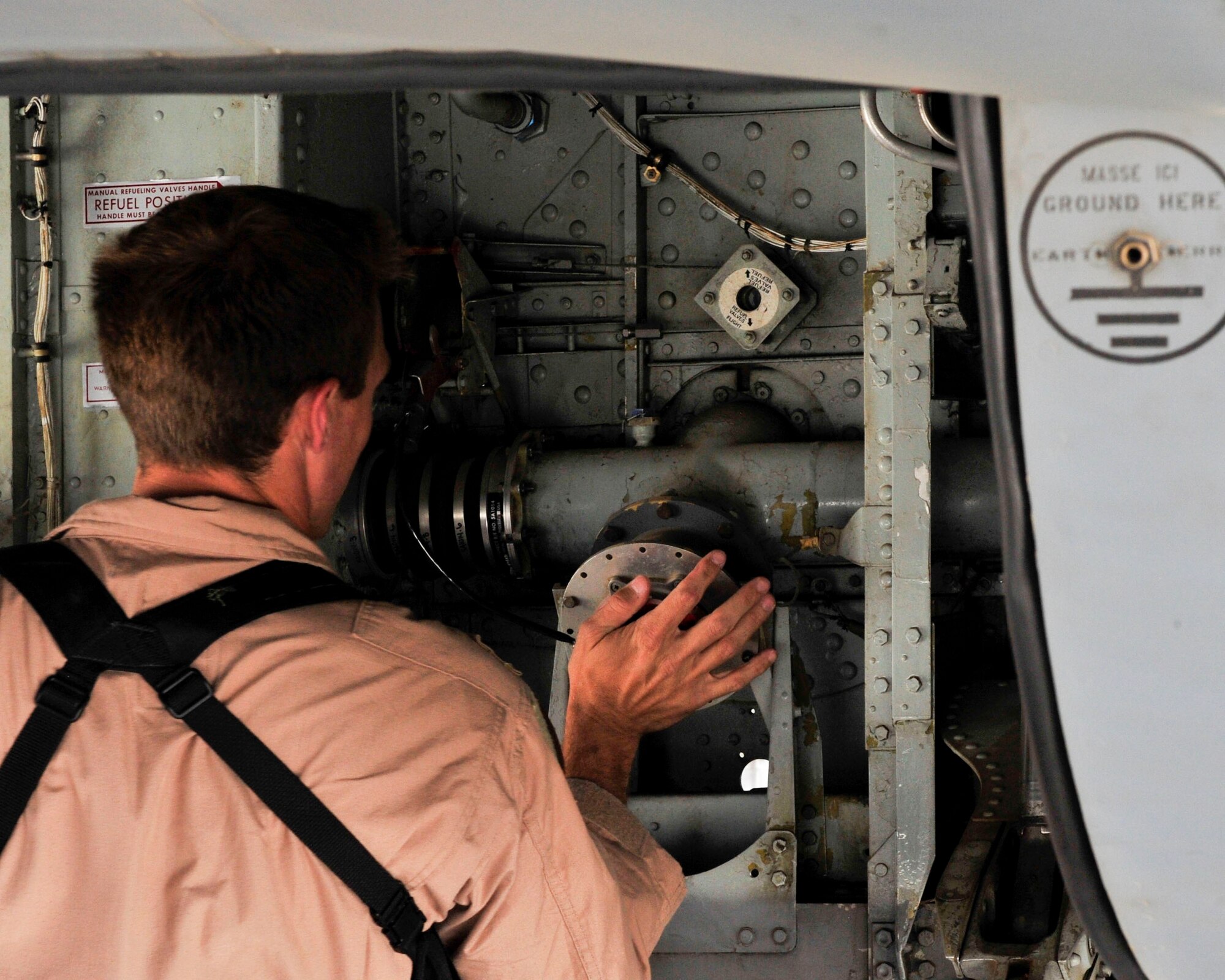 U.S. Air Force Capt. Spencer Lidel, 340th Expeditionary Air Refueling Squadron Detachment 1 KC-135 Stratotanker pilot,inspects the landing gear on a KC-135 Stratotanker at Mazar-i-Sharif Air field, July 24, 2014. The support provided by Det. 1 flying missions has saved the Air Force $28.3 million to date.  (U.S. Air Force photo by Senior Airman Colin Cates) 