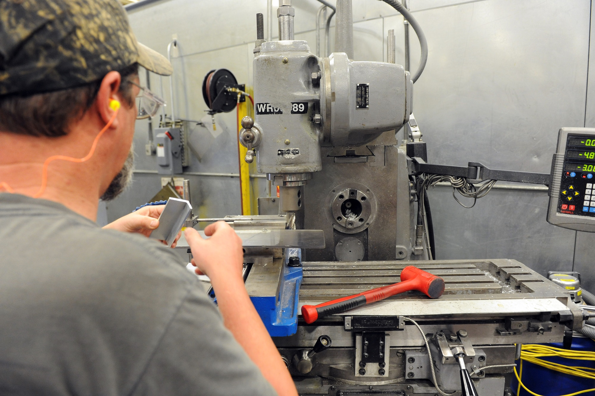 Christopher Crosby, 573rd Commodities Maintenance Squadron machinist, operates a universal milling machine in the production of various critically needed aircraft parts. (U. S. Air Force photo by Tommie Horton)