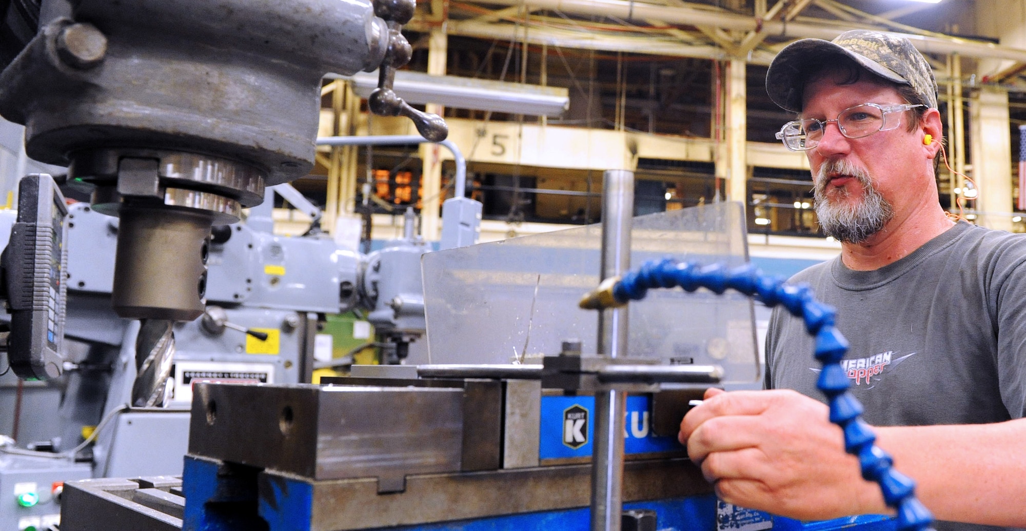 Christopher Crosby, 573rd Commodities Maintenance Squadron machinist, operates a universal milling machine in the production of various critically needed aircraft parts. (U. S. Air Force photo by Tommie Horton)