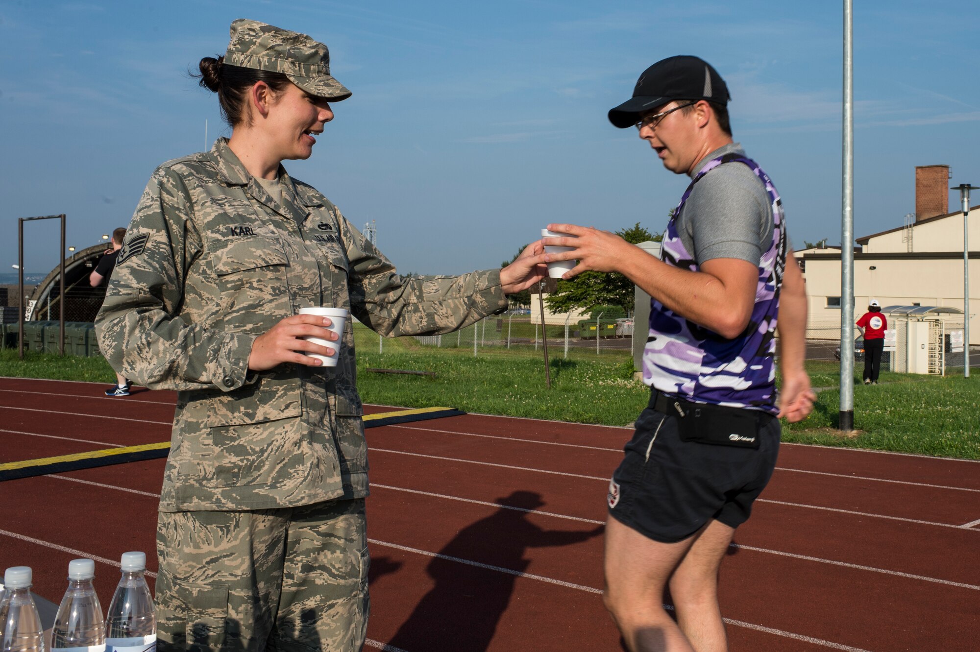 U.S. Air Force Staff Sgt. Catherine Karl, 52nd Logistic Readiness Squadron vehicle operator from Ventura, Calif., provides water to a Relay For Life participant at Spangdahlem Air Base, Germany, Aug. 1, 2014. Exhibitors offered food, drink and games for spectators at the event. (U.S. Air Force photo by Staff Sgt. Christopher Ruano/Released)