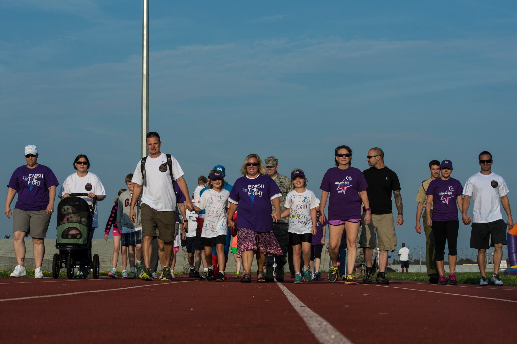 Cancer survivors along with friends and family walk the first laps around the base track during the Relay For Life fundraiser at Spangdahlem Air Base, Germany, Aug. 1, 2014. More than 250 participants signed up for the event with new signups expected throughout the day. (U.S. Air Force photo by Staff Sgt. Christopher Ruano/Released)