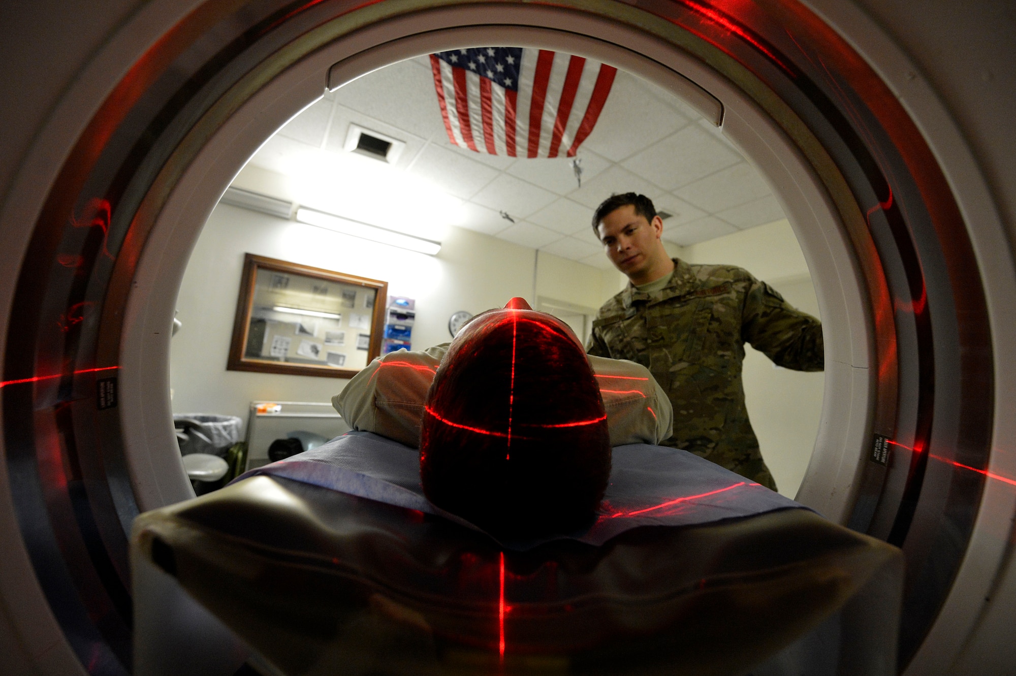 U.S. Air Force Senior Airman Freddy Toruno, 455th Expeditionary Medical Support Squadron diagnostic imaging technologists, positions a service member for a CT scan at Bagram Airfield, Afghanistan’s Craig Joint Theater Hospital July 24, 2014.  The CT scan helps radiologists diagnose different types of disease and injuries, such at traumatic brain injuries.  Toruno is deployed from Travis Air Force Base, Calif. and a native of Miami, Fla.  (U.S. Air Force photo by Staff Sgt. Evelyn Chavez/Released)