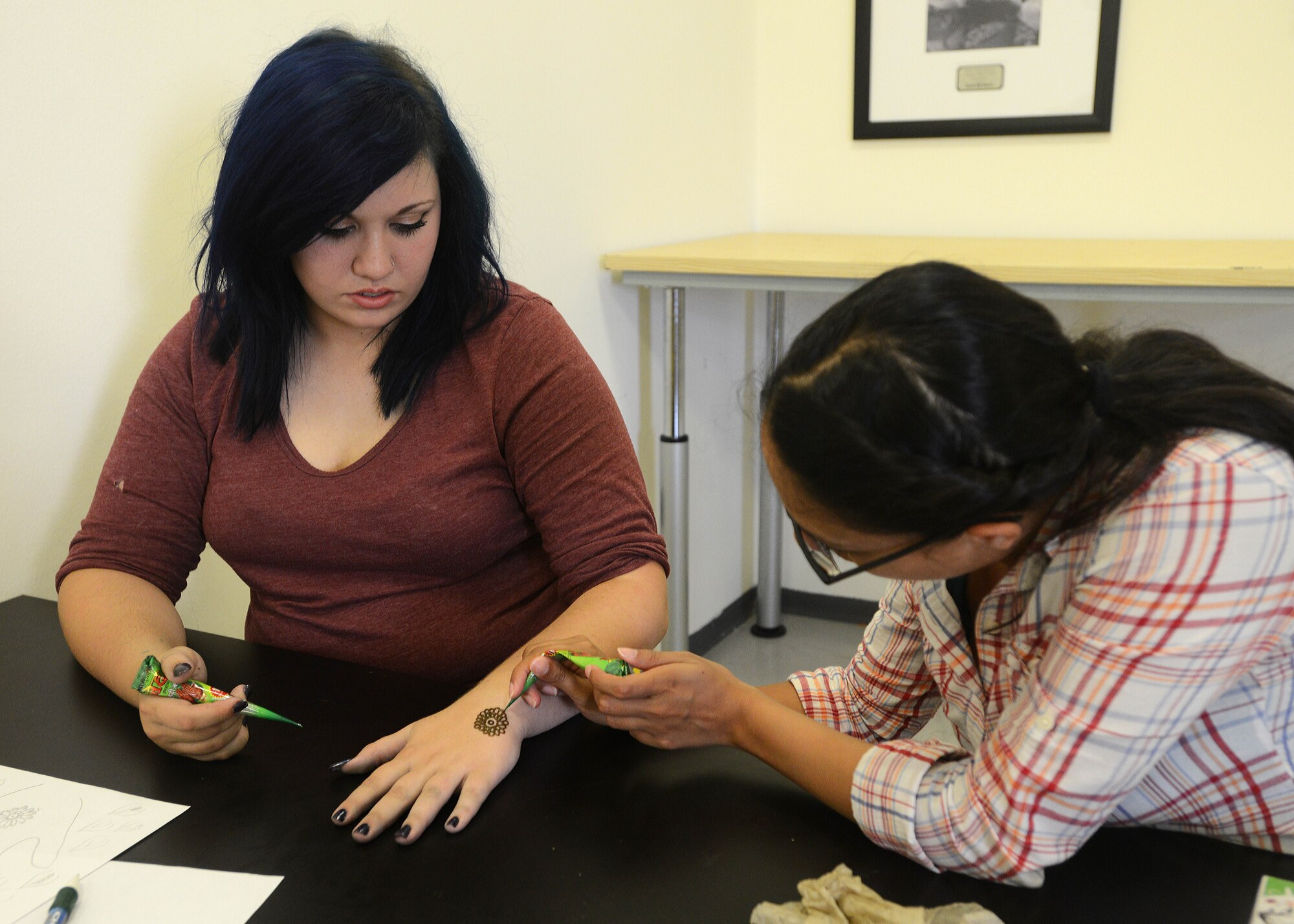 Faiza Nguyen, 31st Force Support Squadron Arts and Crafts Center henna instructor, draws on McKenzie Milligan, during a henna art class, July 31, 2014, at Aviano Air Base, Italy.  Different classes are offered throughout the year such as framing, painting and photography. Team Aviano members can sign up by contacting the Arts and Craft Center two days before the scheduled class. (U.S. Air Force photo/Airman 1st Class Deana Heitzman)  