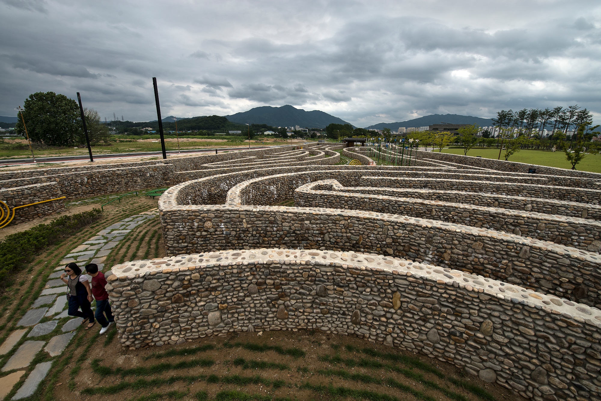A couple walks through a stone-maze park July 26, 2014, in Chungju, Republic of Korea. Chungju is located in the geographical center of the peninsula of Korea, which made it a vaunted territory in ancient times. (U.S. Air Force photo by Staff Sgt. Jake Barreiro)