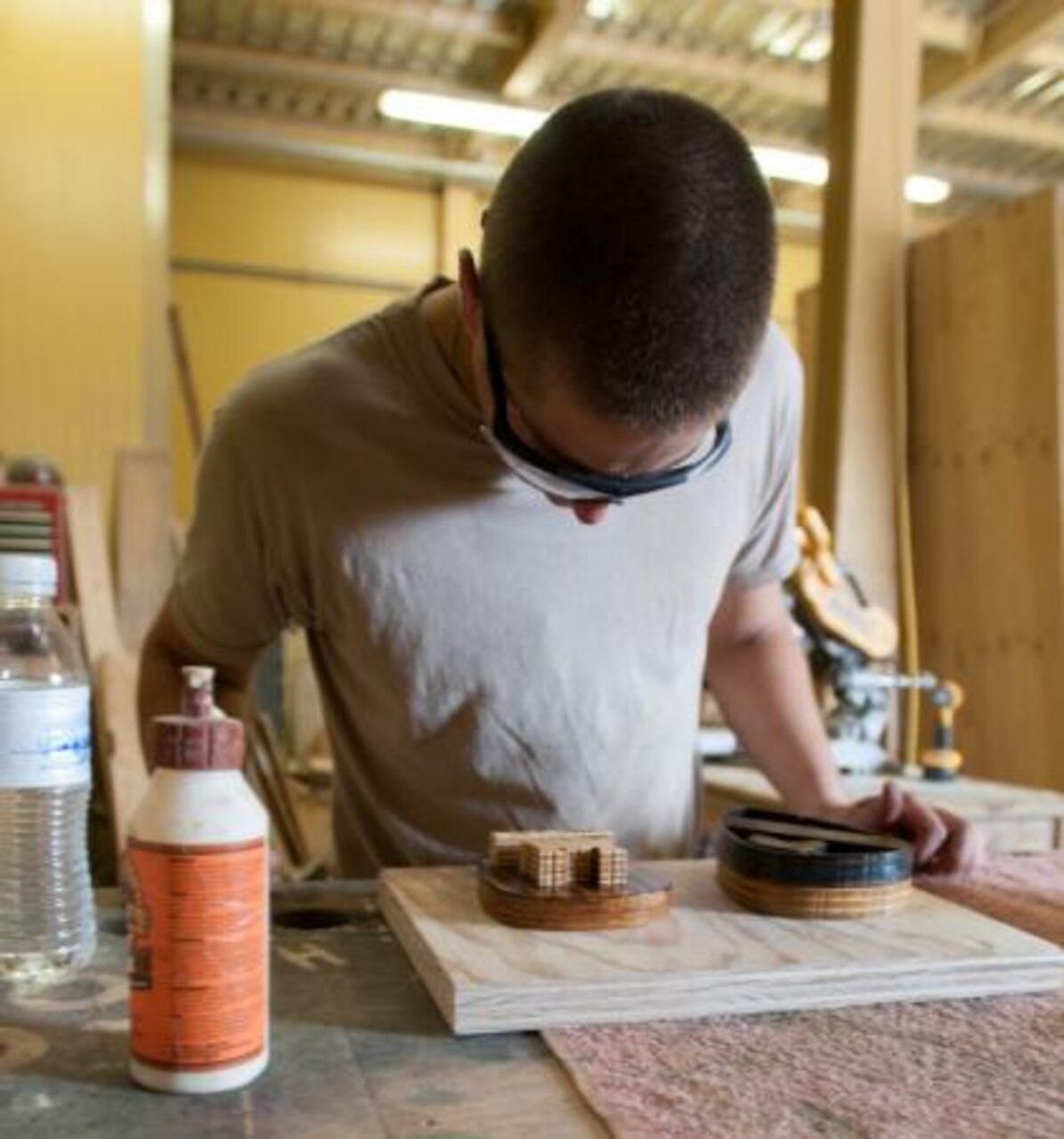 Army Spc. David Beachey from Highland, Ind., who serves with the 1413th Engineer Company, Indiana National Guard, examines his work in the woodshop at Kandahar Airfield, Afghanistan, July 26, 2014. Beachey, the primary sign maker, works for Army Spc. Keith Harris, the shop’s leader. U.S. Army photo by Spc. Ariel J. Solomon