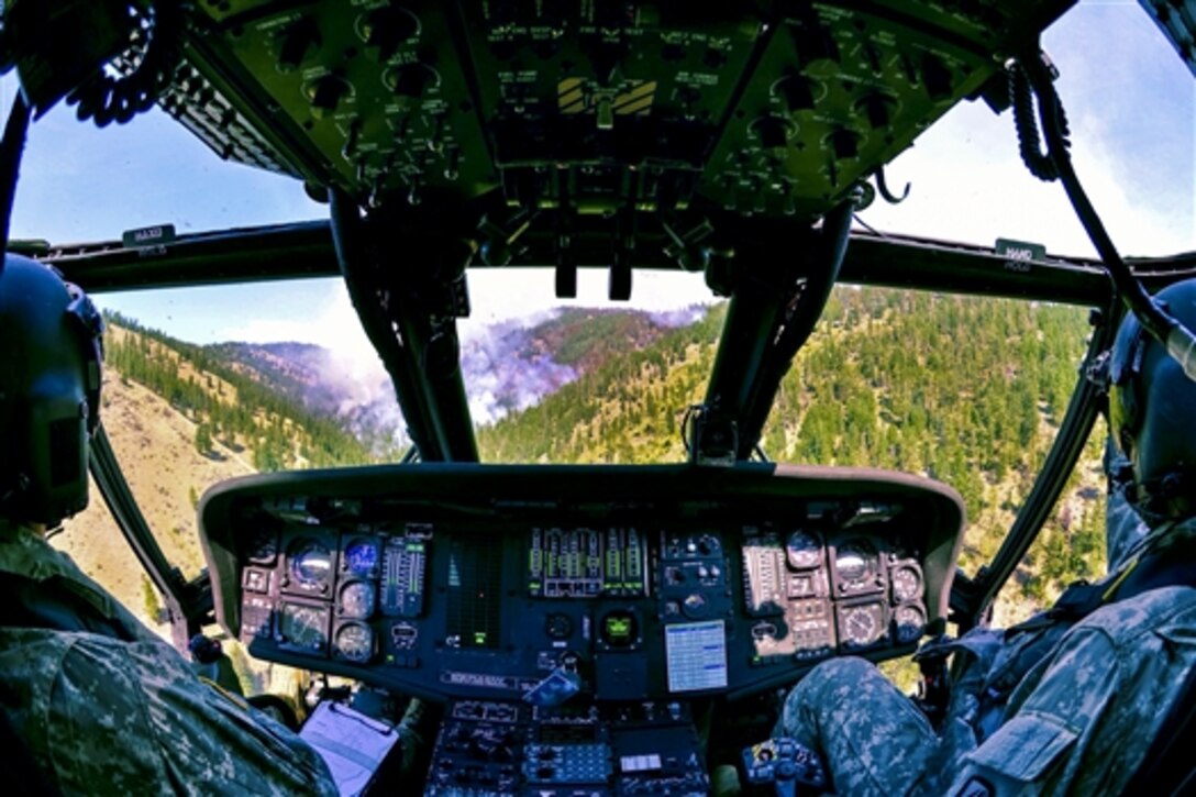 Army Chief Warrant Officer 4 Noel Larson and Army Chief Warrant Officer 2 Nick Gliem line up their UH-60 Black Hawk helicopter for its next water drop to help fight wildfires near the Chiwaukum Creek and Carlton Complex fires outside Leavenworth, Wash., July 31, 2014. Larson and Gliem are pilots assigned to the Washington National Guard's 66th Theater Aviation Command.