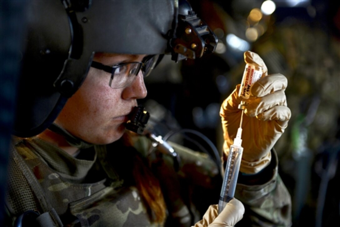 U.S. Army Sgt. Megan Smith fills a syringe during a patient transfer in Afghanistan, July 22, 2014. Smith is a medic assigned to the 159th Combat Aviation Brigade.