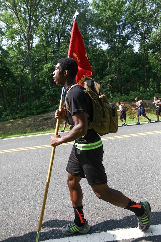 Ahmir Mitchel, a member of the Cedar Creek football team carries the guideon  during the hike at Naval Weapons Station Earle, Aug. 1. Recruiting Station New Jersey hosted a Leadership Seminar meant to impart Marine Corps leadership principles, discipline and camaraderie to members of the Cedar Creek. (United States Marine Corps photo by Lance Cpl. Brandon Thomas)