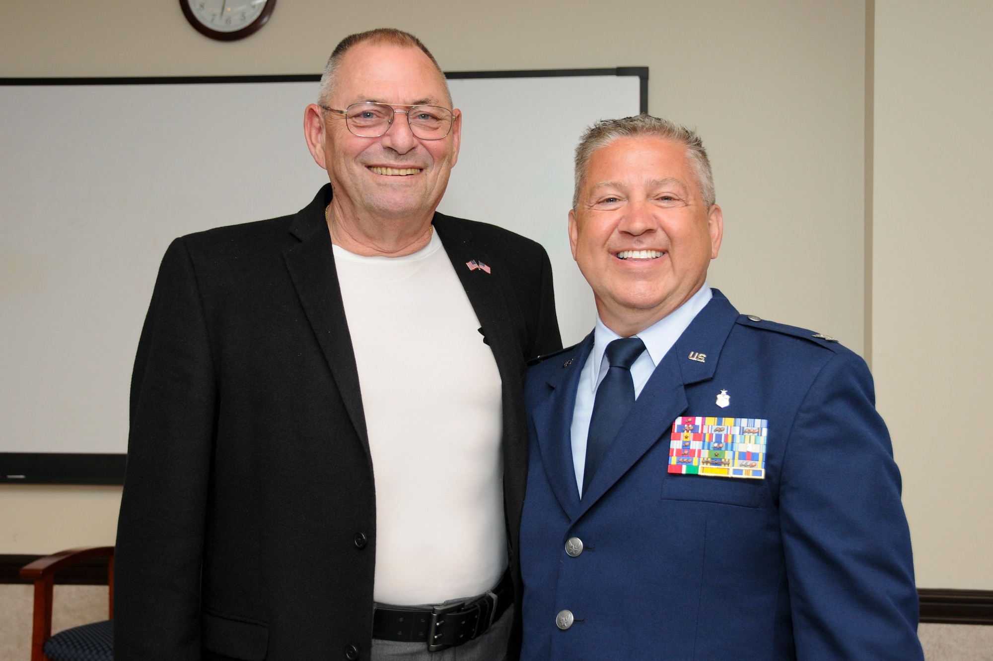Col. Scott Blum, 108th Medical Group commander, poses for a photograph with retired Col. Barry Johnson after Blum's promotion ceremony at Joint Base McGuire-Dix-Lakehurst, N.J., July 7, 2014. The colonel's insignia on Blum's service coat were passed down to him starting from Col. Johnson's father, who gave them to his son, who in turned passed them on to the former Medical Group commander Col. Sandra Long who passed them on to Blum. (U.S. Air National Guard photo by Senior Airman Kellyann Novak/Released)