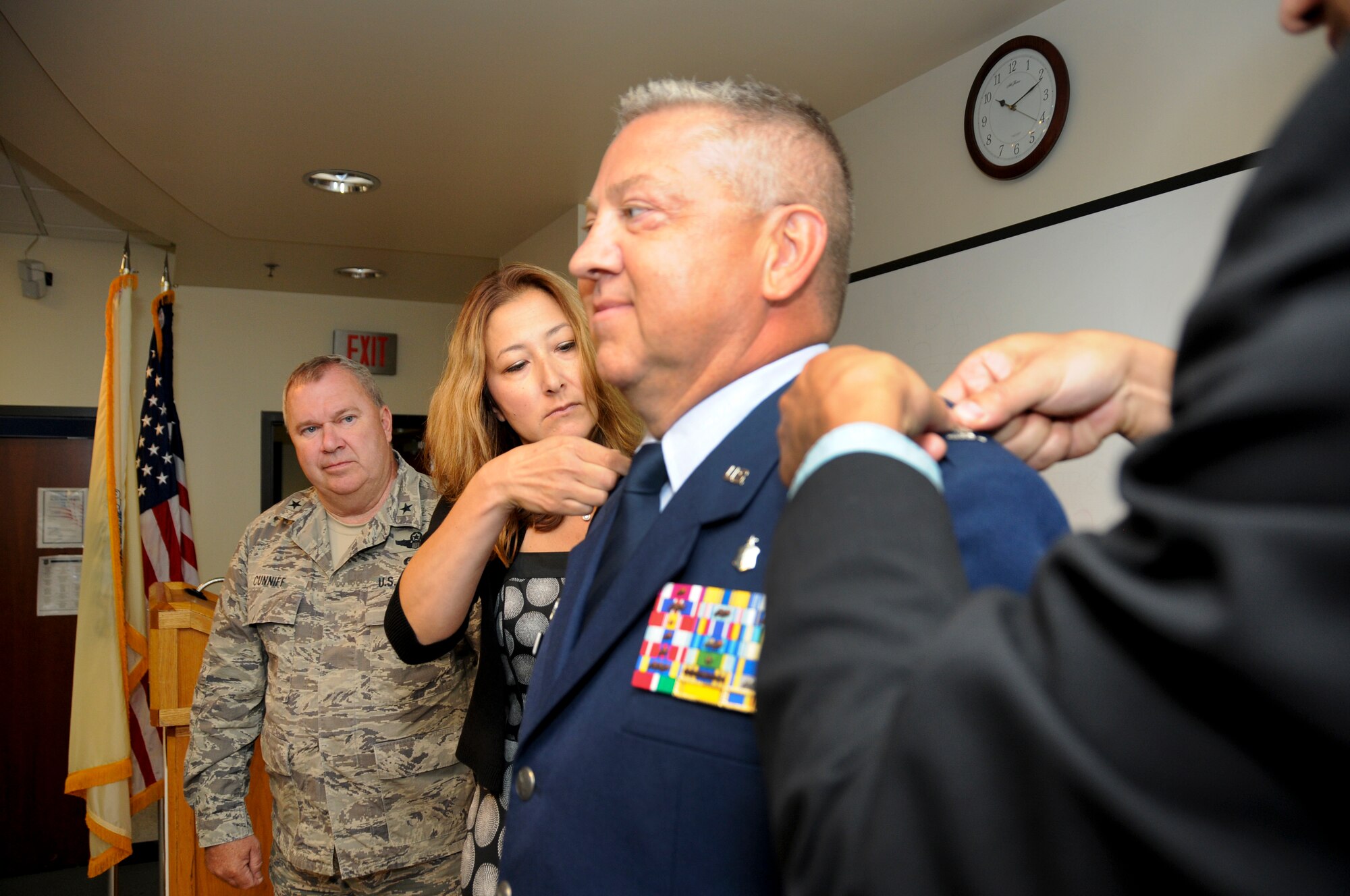 Newly promoted Col. Scott Blum, 108th Medical Group commander, stands proudly as his wife, Patricia, and son, Tyler, pin colonel rank on his service dress coat at his promotion ceremony at Joint Base McGuire-Dix-Lakehurst, N.J., July 7, 2014. (U.S. Air National Guard photo by Senior Airman Kellyann Novak/Released)