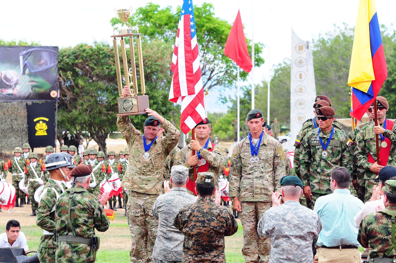 U.S. Soldiers assigned to the 7th Special Forces Group hoist the second place trophy during the closing ceremony of the Fuerzas Comando 2014 competition July 31 in Fort Tolemaida, Colombia. The second place finish was the best performance by the U.S team since the competition was established in 2004. U.S. Army photo by Staff Sgt. Angel Martinez