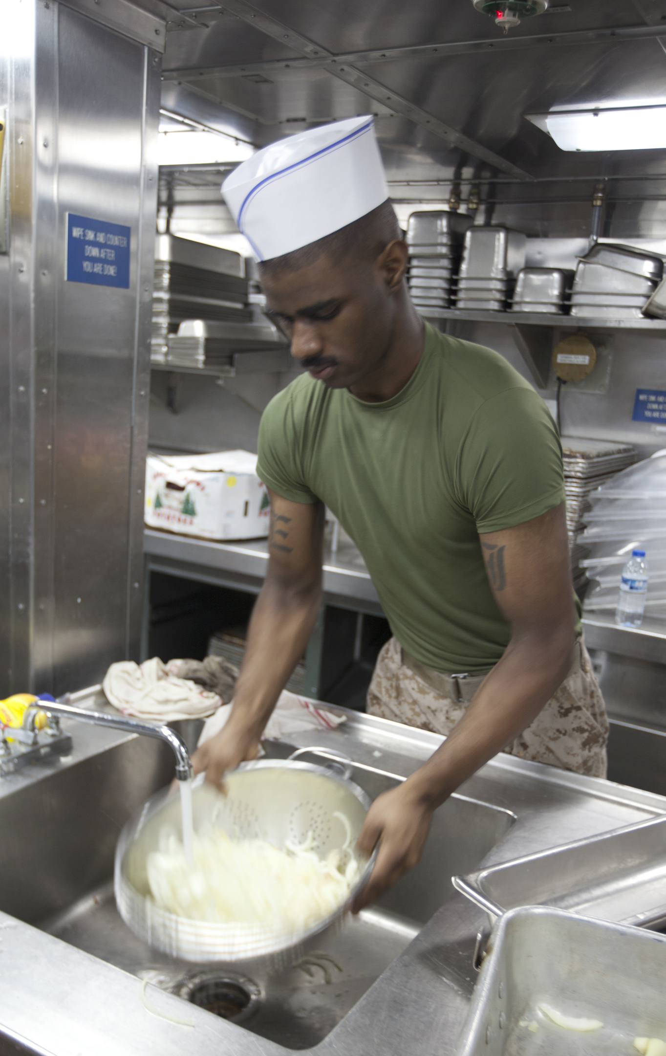 U.S. 5TH FLEET AREA OF RESPONSIBILITY (July 27, 2014) U.S. Marine Corps Cpl. Craig Jenkins, Combat Logistics Battalion 22, 22nd Marine Expeditionary Unit (MEU), food service specialist and native of New Orleans, rinses onions to be served with hamburgers and hot dogs for a steel beach picnic hosted by the Marines aboard the amphibious transport dock ship USS Mesa Verde (LPD 19). The 22nd MEU is deployed with the Bataan Amphibious Ready Group as a theater reserve and crisis response force throughout U.S. Central Command and the U.S. 5th Fleet area of responsibility. (U.S. Marine Corps photo by Staff Sgt. Lukas Atwell/Released)