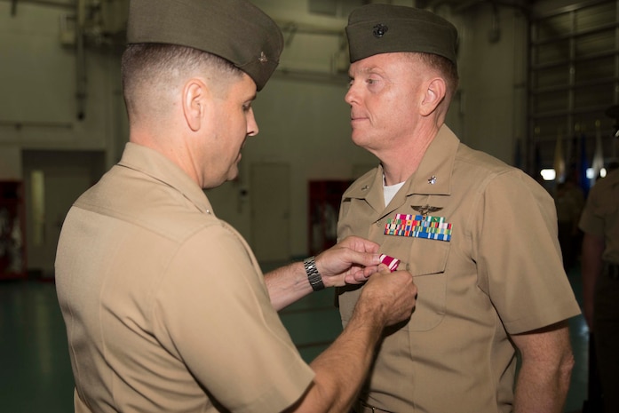 Col. Robert Boucher, station commanding officer, awards Lt. Col. James Walker, station airfield operations officer, the Meritorious Service Medal during his retirement ceremony, July 25, 2014, aboard Marine Corps Air Station Iwakuni Japan. The Meritorious Service Medal is a decoration presented to service members who distinguish themselves by outstanding meritorious achievement or service.