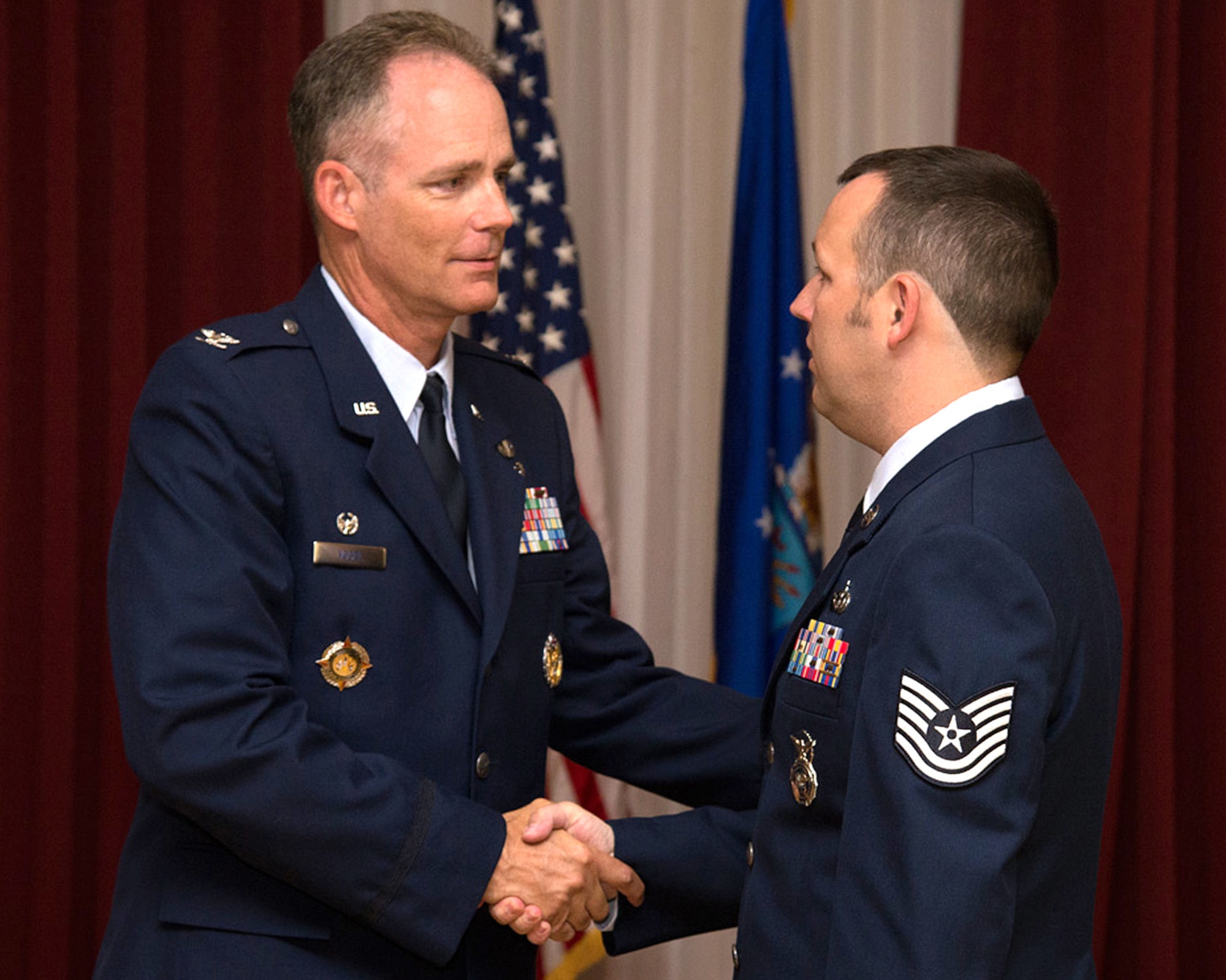 HANSCOM AIR FORCE BASE, Mass. -- Col. Michael A. Vogel, 66th Air Base Group commander, congratulates Tech. Sgt. Richard C. Crotty, 66th Security Forces Squadron Training NCO in charge, after his promotion to technical sergeant during the enlisted monthly promotion ceremony at the Minuteman Commons July 31. At the monthly ceremony, generally held on the last duty day of the month, the Hanscom community recognizes enlisted Airmen selected for promotion. (U.S. Air Force photo by Walter Santos)