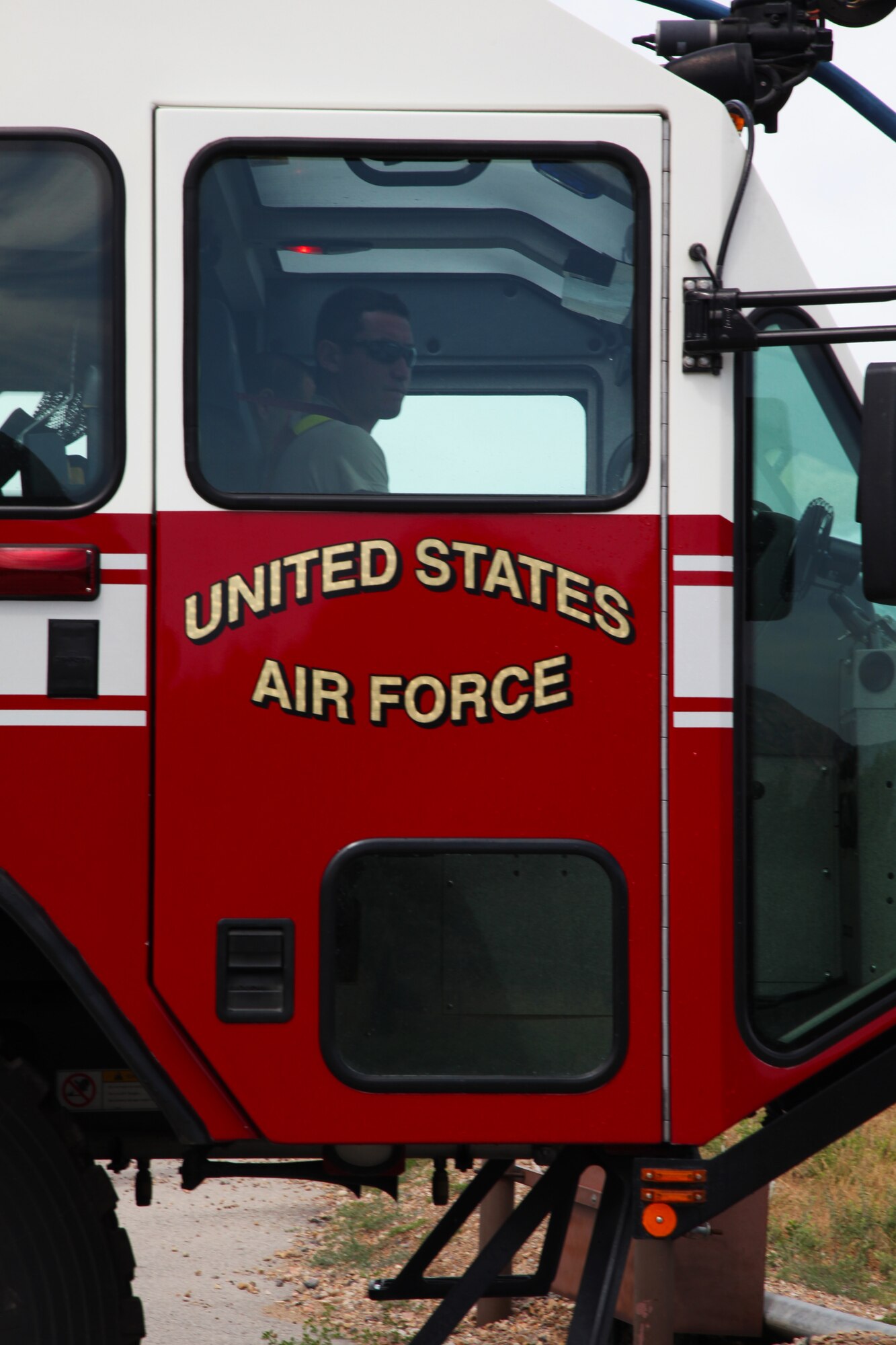 Senior Airman Stanley Zamora, 940th Fire Emergency Services Flight reservist, drives the Striker crash vehicle at the live fire exercise. During the training he sprayed the water from the Striker to assist the ground fire team's entry into the aircraft. (U.S. Air Force photo by Tech Sgt. Kenneth McCann/Released) 
