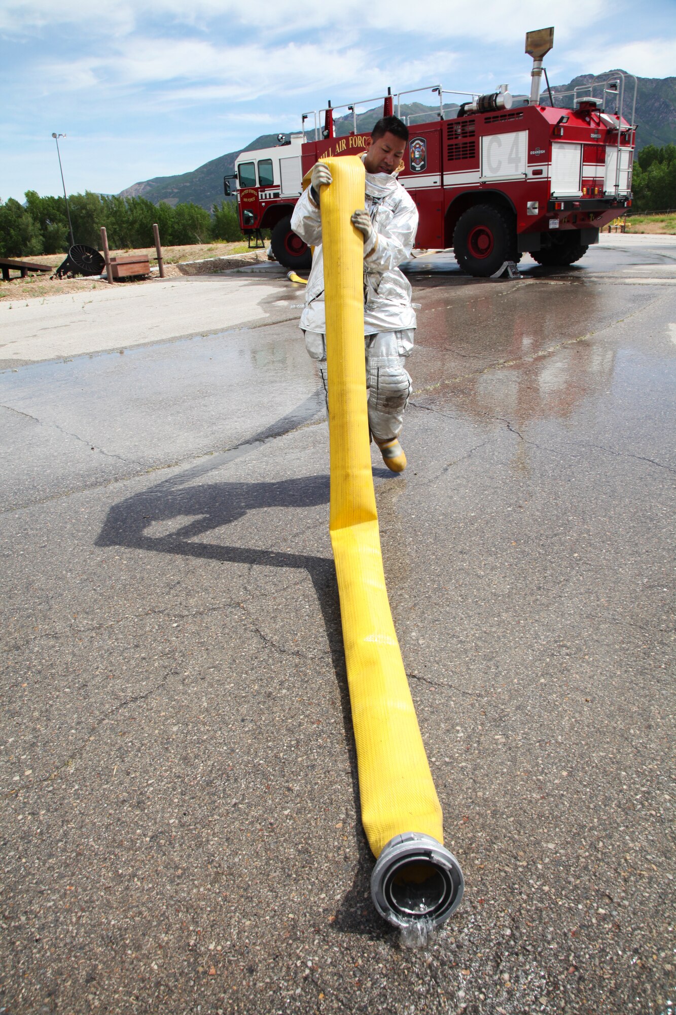 Staff Sgt. Roderick Tan, 940th Fire Emergency Services Flight reservist,  drains water from the Striker crash vehicle's large diameter hose. The vehicle is used by Air Force firefighters to battle flightline fire emergencies. (U.S. Air Force photo by Tech. Sgt. Kenneth McCann/Released) 