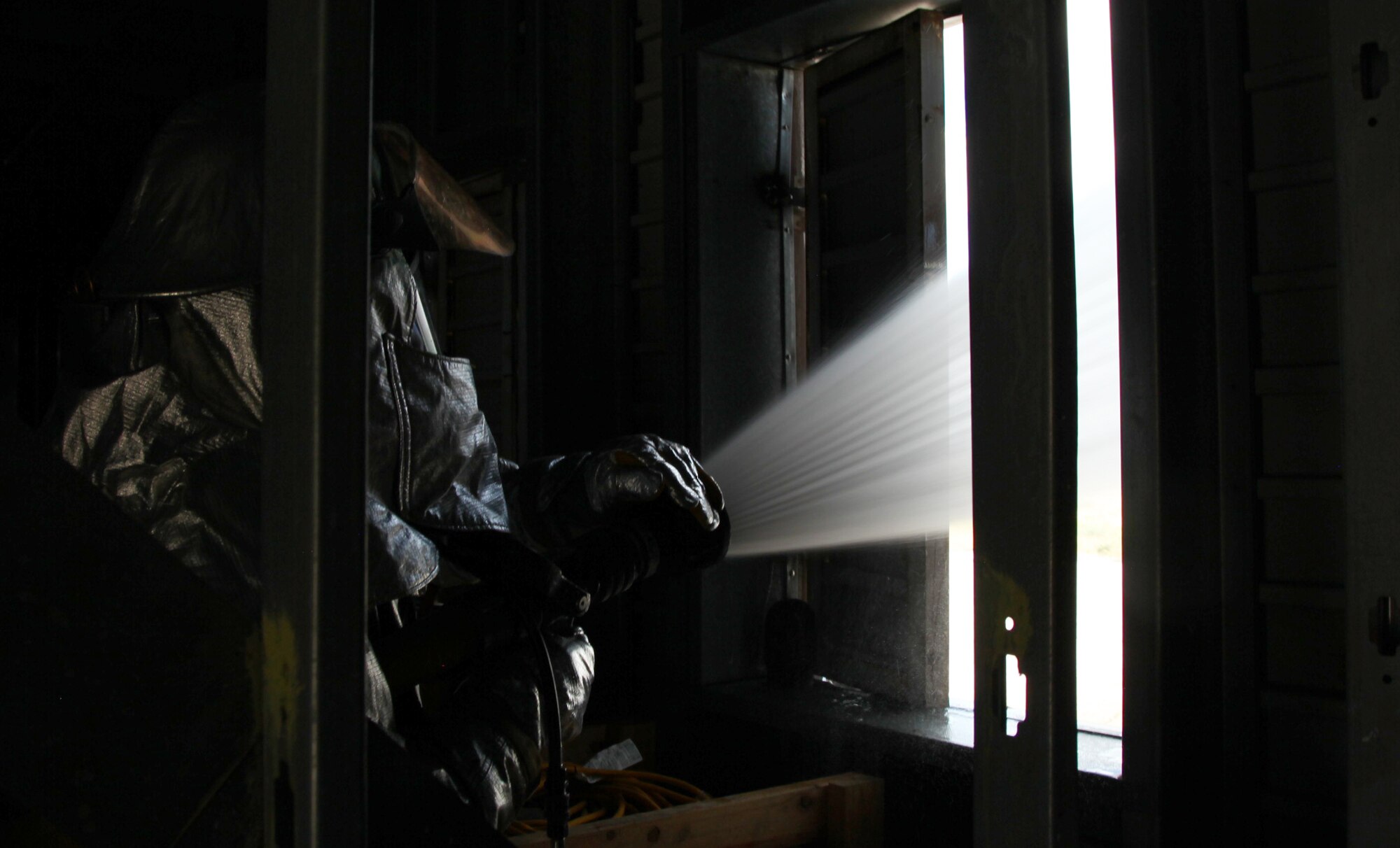 Senior Airman Stanley Zamora, 940th Wing Fire Emergency Services Flight reservist,
performs hydraulic ventilation inside a training tower to remove simulated
heat and smoke from the room. The room is ventilated to make it easier to
find victims and makes the atmosphere more survivable. (U.S. Air Force
photo by Tech Sgt. Kenneth McCann/Released) 
