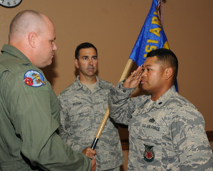 (Left) Colonel Gary D. Brewer, Jr., 161st Air Refueling Wing commander, hands a guidon to Lt. Col. Eric A. Queddeng, 161st Civil Engineering Squadron commander, during an Assumption of Command ceremony, Phoenix Sky Harbor Air National Guard Base, Phoenix, Aug. 2, 2014. Members of the 161 ARW welcome Queddeng, his wife Bensy, and daughter Emerald from the 96th Civil Engineering Squadron, Eglin Air Force Base, Fla. Queddeng has served in a variety of positions at the base level and numbered air force staff, as well as deployed to Wake Island, Kuwait, Iraq, and twice to Afghanistan.