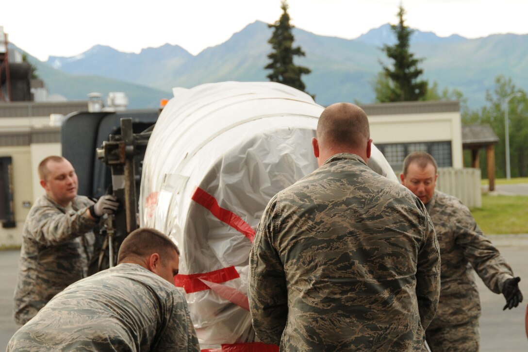 Guardsmen with the 186th Logistics Readiness Squadron (LRS), Mississippi Air National Guard (ANG), load a C-130 Hercules engine on a trailer at Joint Base Elmendorf-Richardson (JBER) in Anchorage, Alaska, July 23, 2014. The 186th LRS was involved in joint training with Air Force active duty and ANG units from Alaska, Maine, Tennessee and Mississippi. (Air National Guard photo by 2nd Lt. Sabrina Dalton/Released)