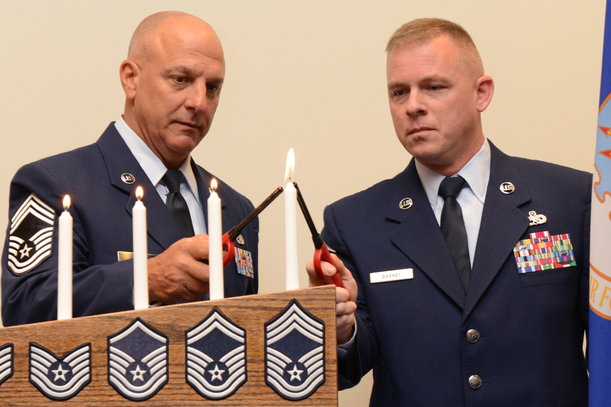 Chief Master Sgts. Vincent Armata (left), 403rd Maintenance Squadron aircraft maintenance superintendent, and Christopher Barnby, 403rd Wing Command Chief Master Sergeant, take part in a candle-lighting ceremony at the Senior Non-Commissioned Officer and Non-Commissioned Officer Induction Ceremony held August 2, 2014, at the Roberts Aircraft Maintenance Facility on Keesler Air Force Base, Mississippi. The purpose of the ceremony was to recognize their accomplishments and acknowledge the importance of leadership at the NCO and Senior NCO level. (U.S. Air Force photo/Tech. Sgt. Ryan Labadens)