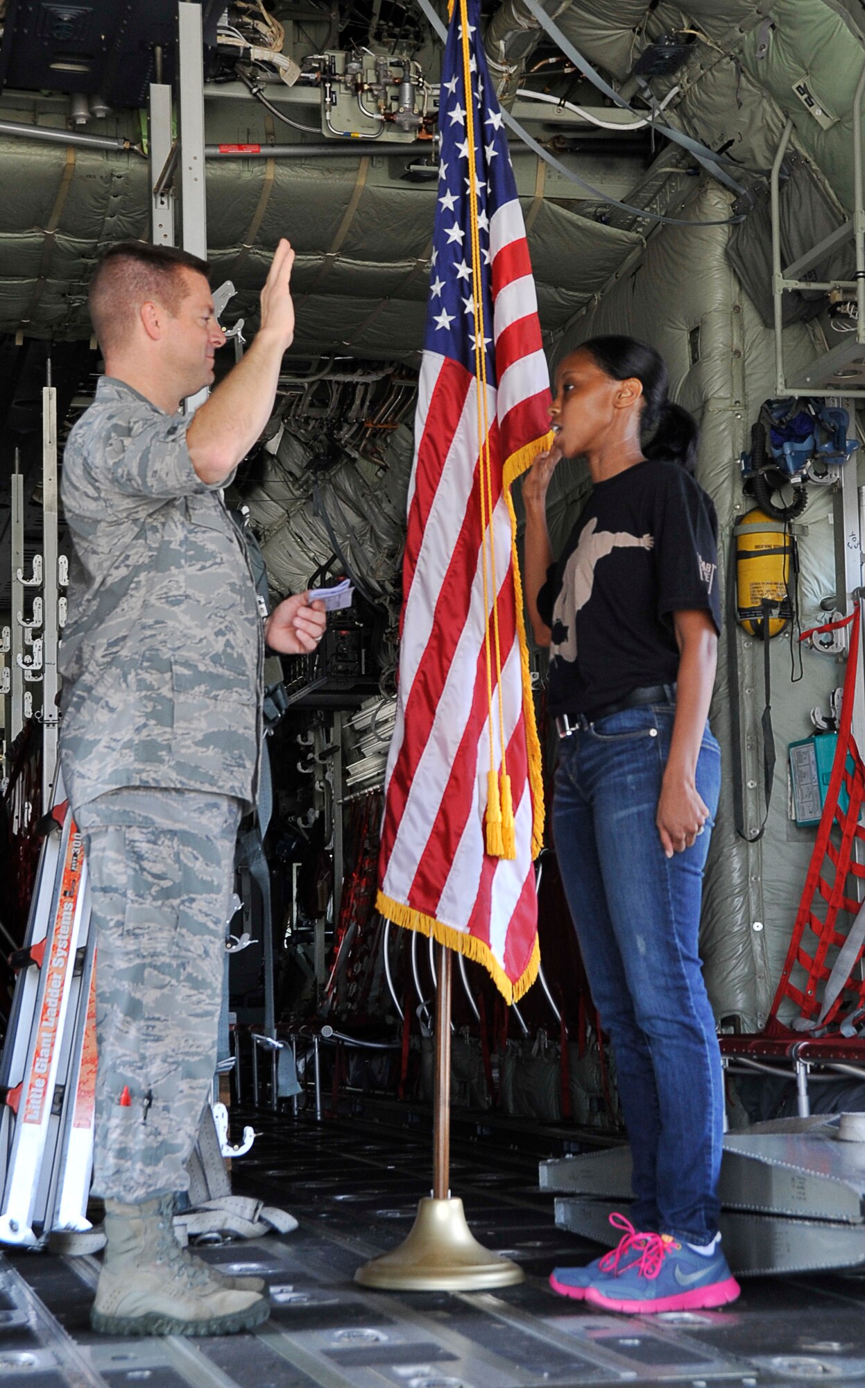 Col. Frank L. Amodeo, 403rd Wing commander, administers the oath of enlistment to Airman 1st Class Shea Bogan, 403rd Developmental Training Flight member, at Keesler Air Force Base, Mississippi, Aug. 3, 2014.  Bogan’s enlistment took place inside a 53rd Weather Reconnaissance Squadron WC130J aircraft.  (U.S. Air Force photo/Master Sgt. Jessica Kendziorek)