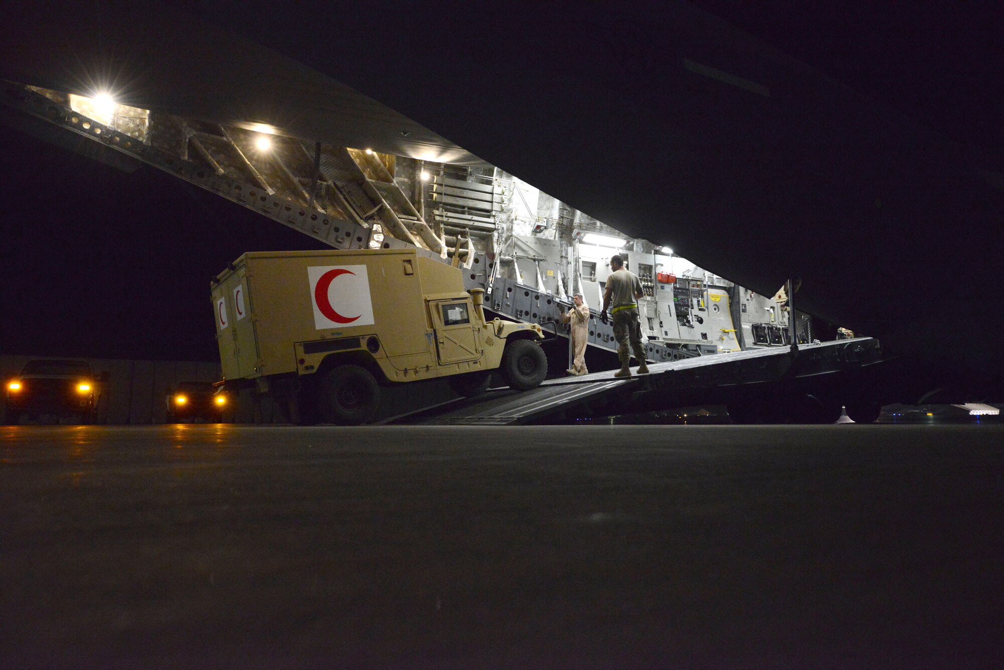 U.S. Air Force Senior Airman Jerry Hullette, a ramp specialist assigned to the 455th Expeditionary Aerial Port Squadron, watches as Master Sgt. John Sadorf, a C-17 Globemaster III loadmaster assigned to the 817th Expeditionary Airlift Squadron, guides the driver of an Afghan ambulatory vehicle as he backs off of the aircraft at Bagram Airfield, Afghanistan July 20, 2014. Airmen assigned to the 455 EAPS worked with two loadmasters to off-load six Afghan ambulatory vehicles before uploading two Heavy Expanded Mobility Tactical Trucks within two hours of landing at Bagram. Hullette is a native of Lincolnton, N.C.  and deployed from the 436th Aerial Port Squadron, Dover Air Force Base, Delaware, and Sadorf is a reservist deployed from the 313th Airlift Squadron, McChord Field, Washington. (U.S. Air Force photo by Master Sgt. Cohen A. Young/Released)