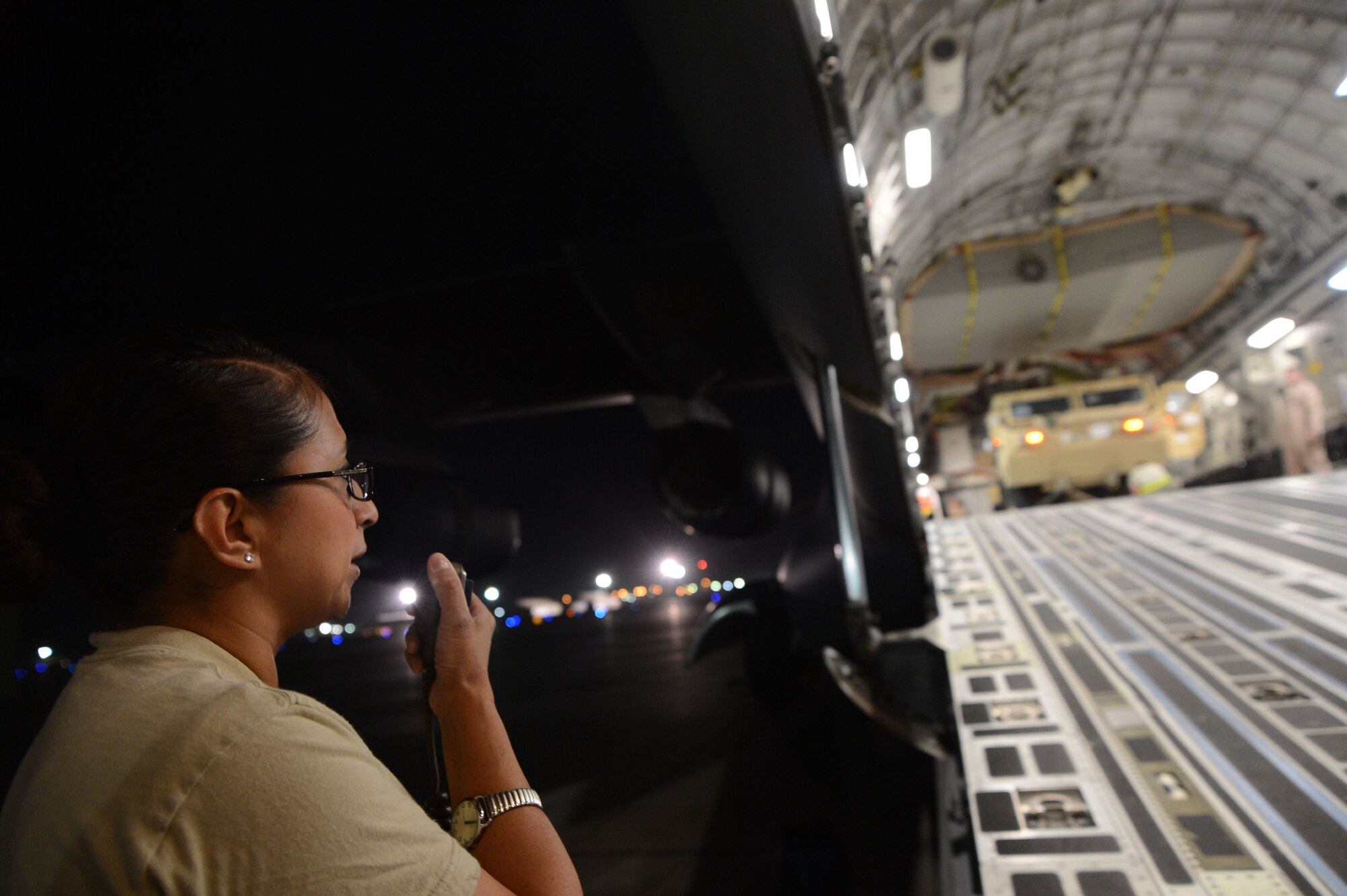 U.S. Air Force Tech. Sgt. Norma Martinez, an information controller assigned to the 455th Expeditionary Aerial Port Squadron, radios the Air Tactical Operations Center the status of the vehicle loading procedures aboard a C-17 Globemaster III at Bagram Airfield, Afghanistan July 20, 2014. Martinez, a reservist, is a resident of San Antonio, Texas and deployed from the 26th Aerial Port Squadron, Joint Base San Antonio, Texas. (U.S. Air Force photo by Master Sgt. Cohen A. Young/Released)