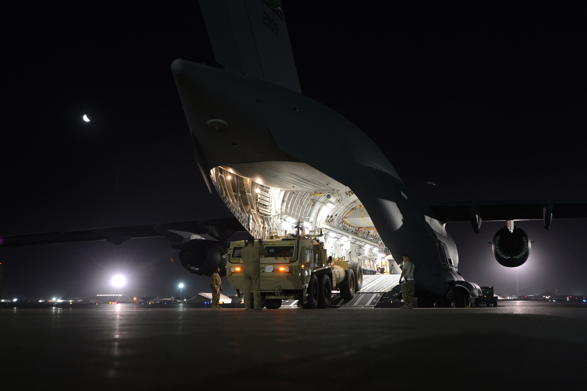 U.S. Air Force Master Sgt. John Sadorf, a C-17 Globemaster III loadmaster deployed from the 313th Airlift Squadron, McChord Field, Wash., guides the driver of a Heavy Expanded Mobility Tactical Truck as he backs into the aircraft as part of a redeployment mission. The C-17 crew teamed with Airmen assigned to the 455th Expeditionary Aerial Port Squadron to off-load six Afghan ambulatory vehicles before uploading two Heavy Expanded Mobility Tactical Trucks at Bagram Airfield, Afghanistan July 20, 2014. Sadorf is a native of Puyallup, Washington.  (U.S. Air Force photo by Master Sgt. Cohen A. Young/Released)