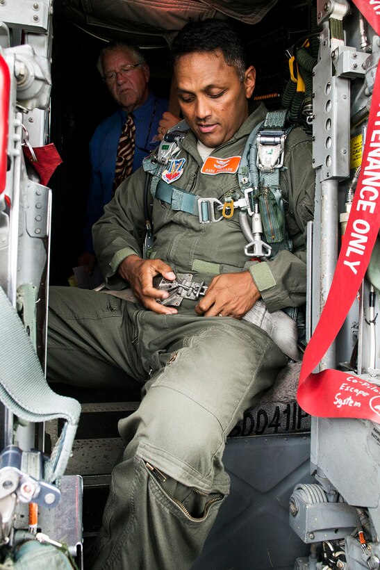 U.S. Air Force Capt. Dave Prakash, aircraft commander and flight surgeon, straps into the instructor pilot seat of a 307th Bomb Wing B-52H Stratofortress under the watchful eye of Philip Hardinger, July 24, 2014, at Barksdale Air Force Base, La. Hardinger is the base Chiropractor assigned to the 2nd Medical Squadron and is studying the physical effects on the body from sitting long hours in an ejection seat. (U.S. Air Force photo by Master Sgt. Greg Steele/Released)