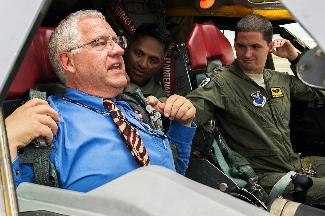 Philip Hardinger, Doctor of Chiropractic, straps on a parachute attached to an ejection seat in a 307th Bomb Wing B-52H Stratofortress to get a feel for what aircrew experience during a mission, July 24, 2014, at Barksdale Air Force Base, La. Hardinger is studying the effects to help prevent and treat back injuries experienced by crew members. (U.S. Air Force photo by Master Sgt. Greg Steele/Released)