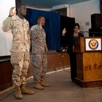 Navy Petty Officer 3rd Class Kelan Scott of Naval Mobile Construction Battalion 5 and Army Sgt. Joel Lara of C Battery, 1st Battalion 161st Field Artillery, Kansas Army National Guard, recite the oath of allegiance to the United States in front of fellow Soldiers and Sailors during a naturalization ceremony held Jan. 25, at Camp Lemonnier, Djibouti. Both Lara and Scott said they left their respective countries for a higher quality living standard as well as education.