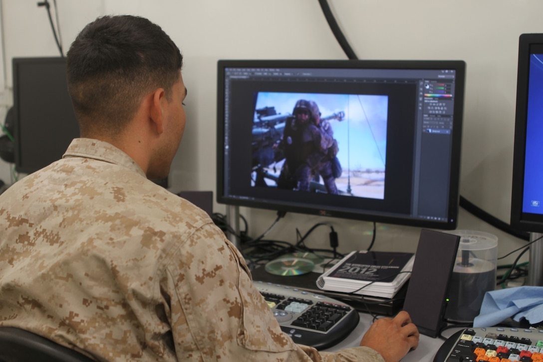 Lance Cpl. James A. Trevino, a combat videographer with 1st Marine Expeditionary Brigade, practices reproduction and photo editing inside a Tactical Imagery Production System during Large Scale Exercise 2014 aboard Marine Corps Air Ground Combat Center Twentynine Palms, Calif., Aug. 2, 2014. LSE-14 is a bilateral training exercise being conducted by 1st MEB to build U.S. and Canadian forces' joint capabilities through live, simulated, and constructive military training activities from Aug. 8-14. (U.S. Marine Corps photo by Lance Cpl. Angel Serna/Released)